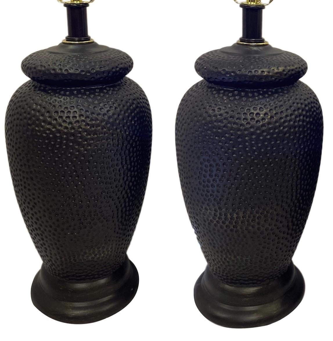 Pair of circa 1960s French ceramic lamps with hammered texture.

Measurements:
Height of body: 15″
Height to rest of shade: 24.5″
Diameter: 8″