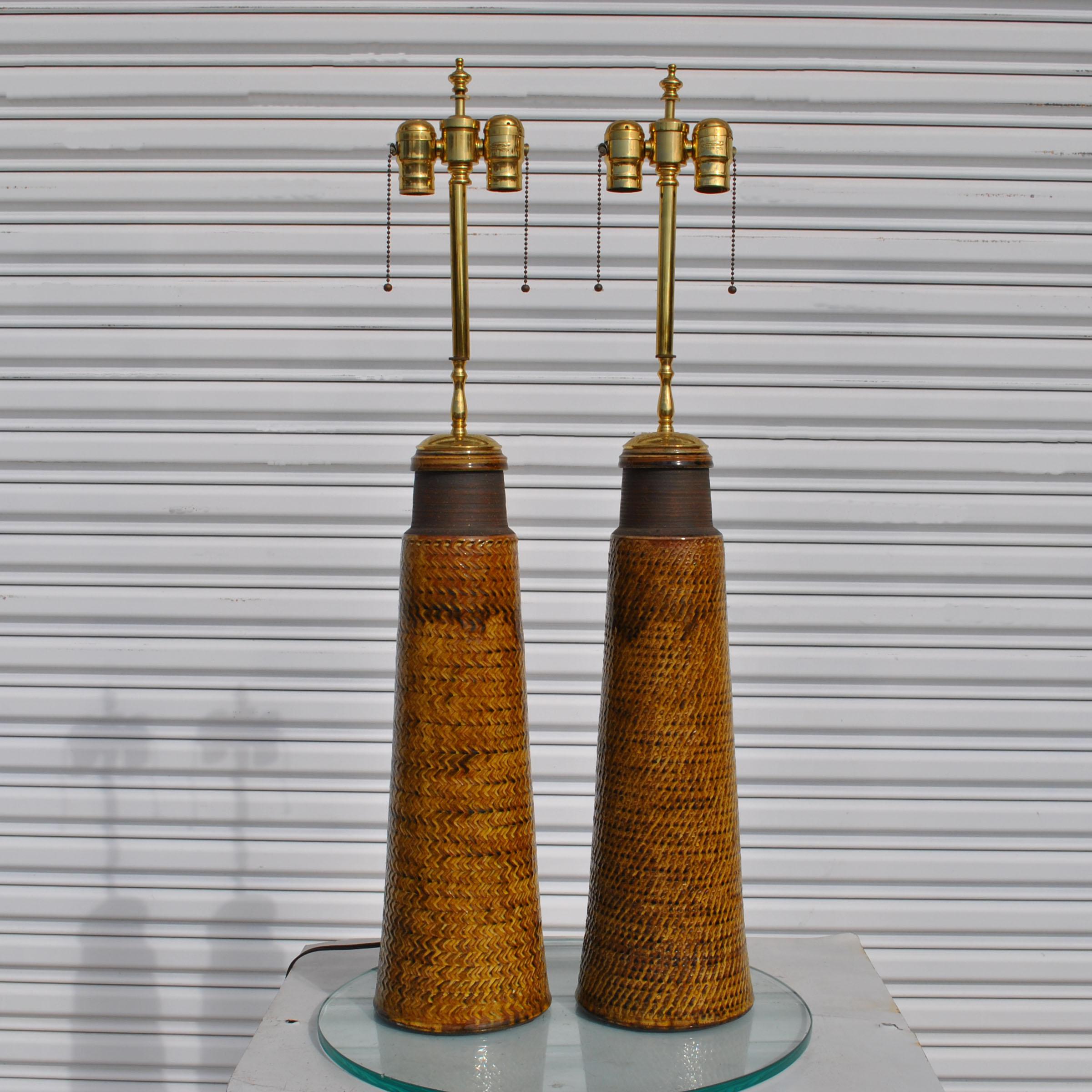 A pair of mid century modern ceramic table lamps featuring a surface with a woven design.  Newly rewired and restored.
