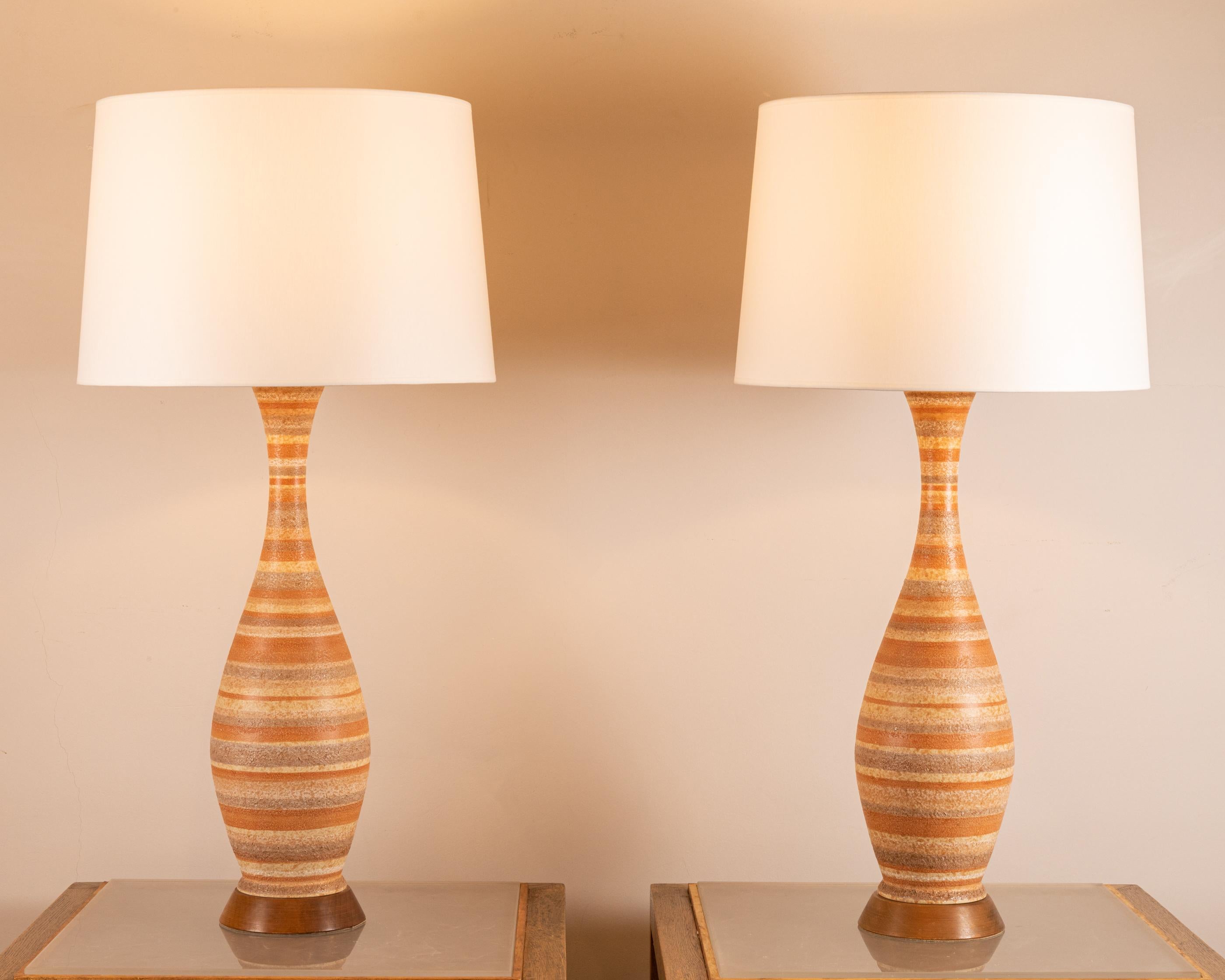 Pair of tall bottle-shaped ceramic lamps
 With stripes motives.
On wood bases.
Attributed to Bitossi
Italy, 1950’s
Height ( total with shade) : 90 cm (35,43 inch)
Height ( ceramic) : 60 cm (23,62 inch )
Diameter ( shades ) : 45 cm (17,71