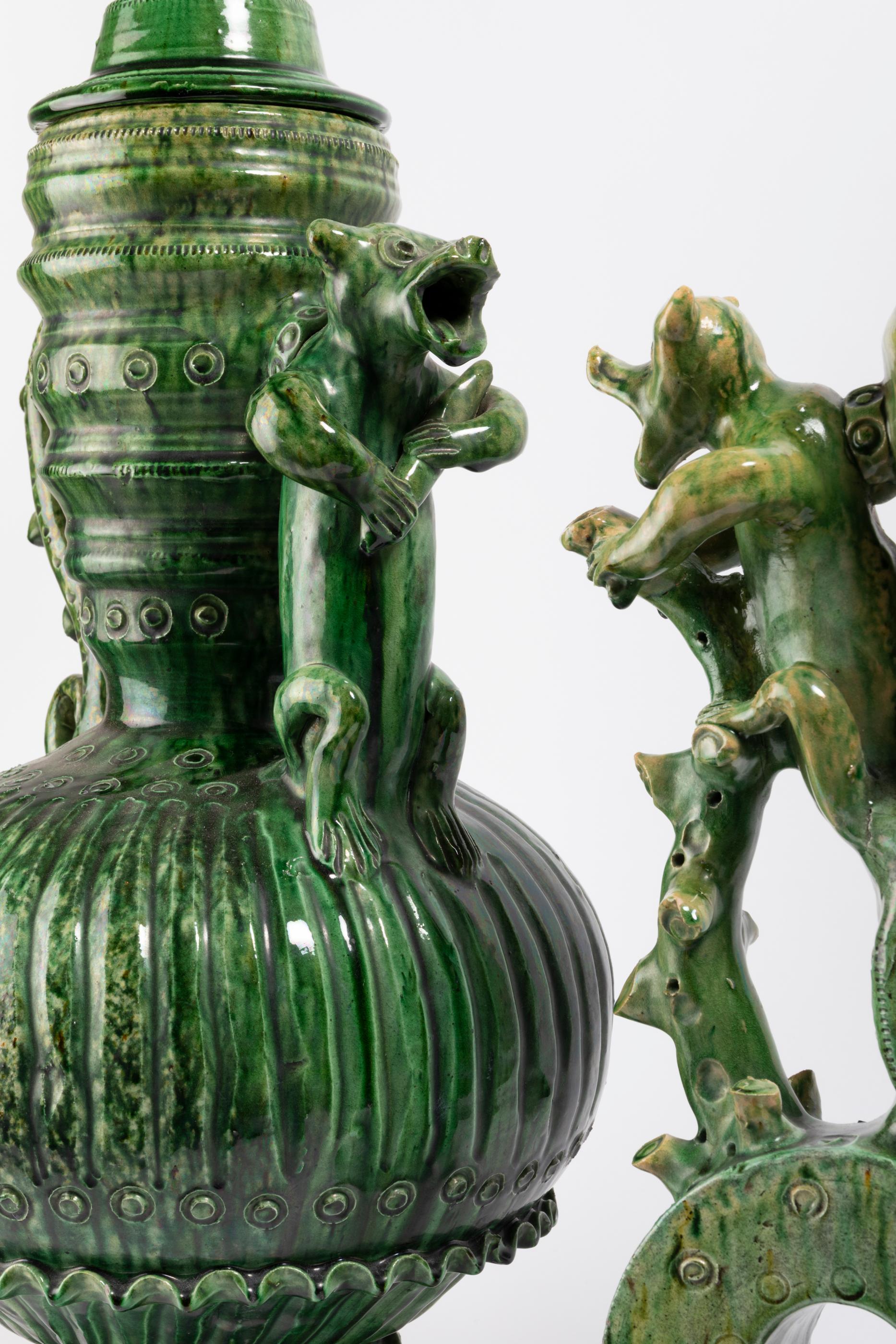 Pair of vases with molded lids figuring a bird.
Green glazed clay vases with molded-relief decoration. 
In the style of the Pré d'Auge, Malicorne or Saintonge production from the sixteenth to the nineteenth century.
France,