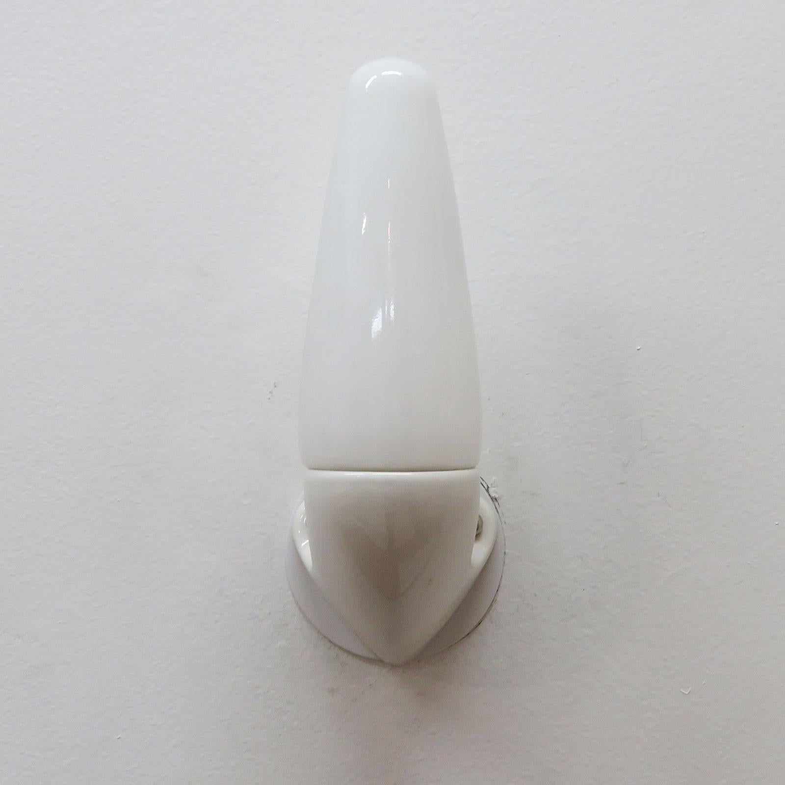 Maravillosa pareja de apliques de porcelana marfil con tapas de bombillas de cristal opaco, de Sigvard Bernadotte para Ifö, Suecia, mostrados con placas traseras personalizadas. Un casquillo E12 por aparato, potencia máx. de 60 vatios cada uno o