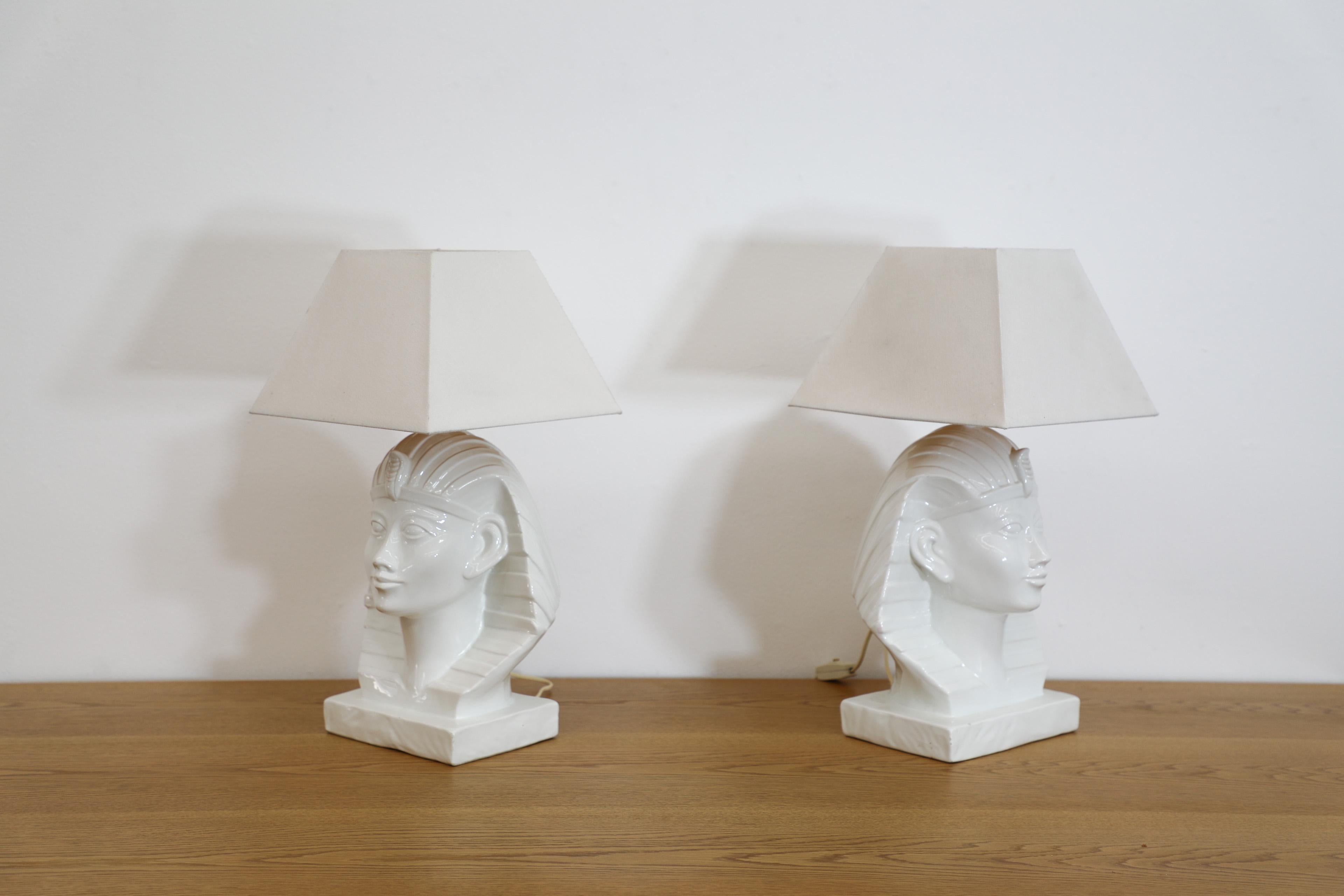 Ensemble de deux lampes de table des années 1980, avec base de buste de pharaon en céramique émaillée blanche. Les bustes sont inspirés du portrait de Toutânkhamon, le célèbre garçon-roi de l'Égypte ancienne. Les lampes sont conçues dans le style du