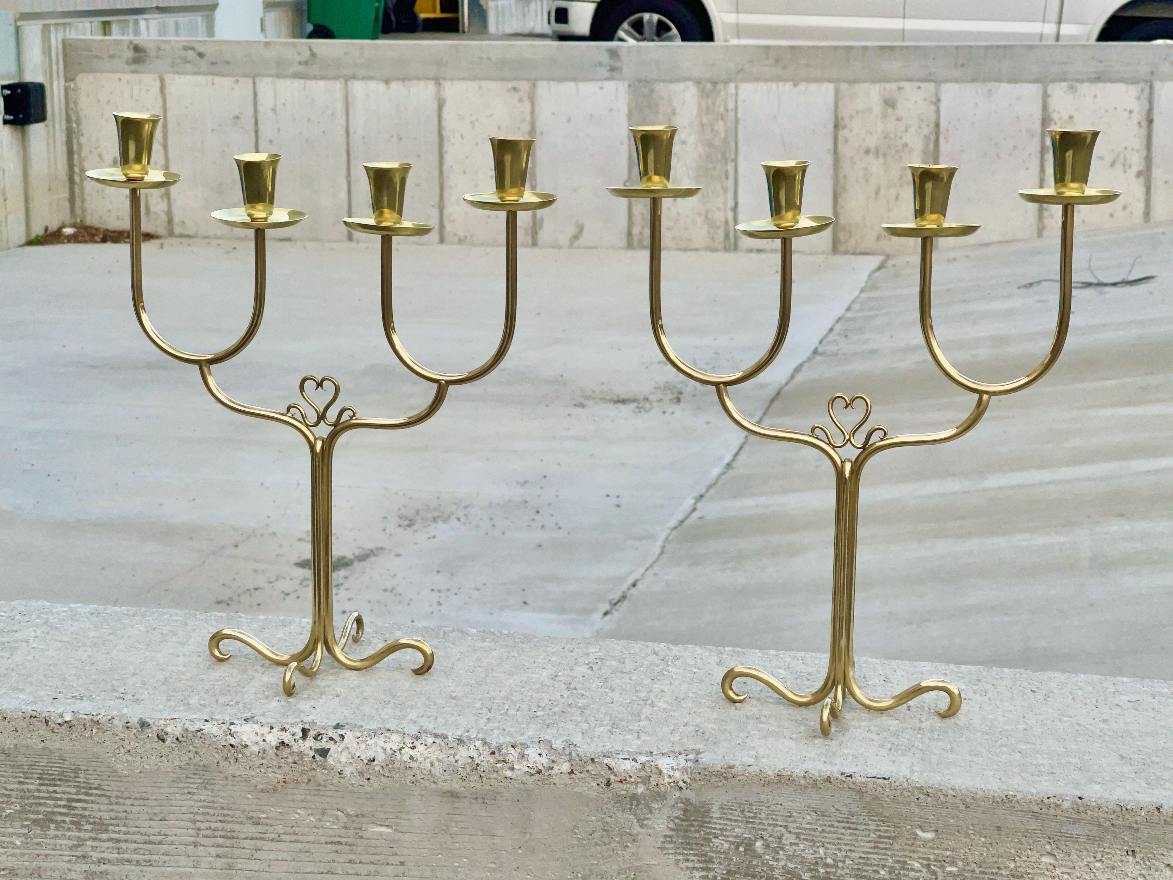 Pair of solid brass Italian 1950's candelabra by architect-designer, Cesare Lacca.
Each holds four candle tapers.
Look closely at the phenomenally skillful brass work using solid brass rod.  The ends look almost like pulled taffy!
Each cup unscrews