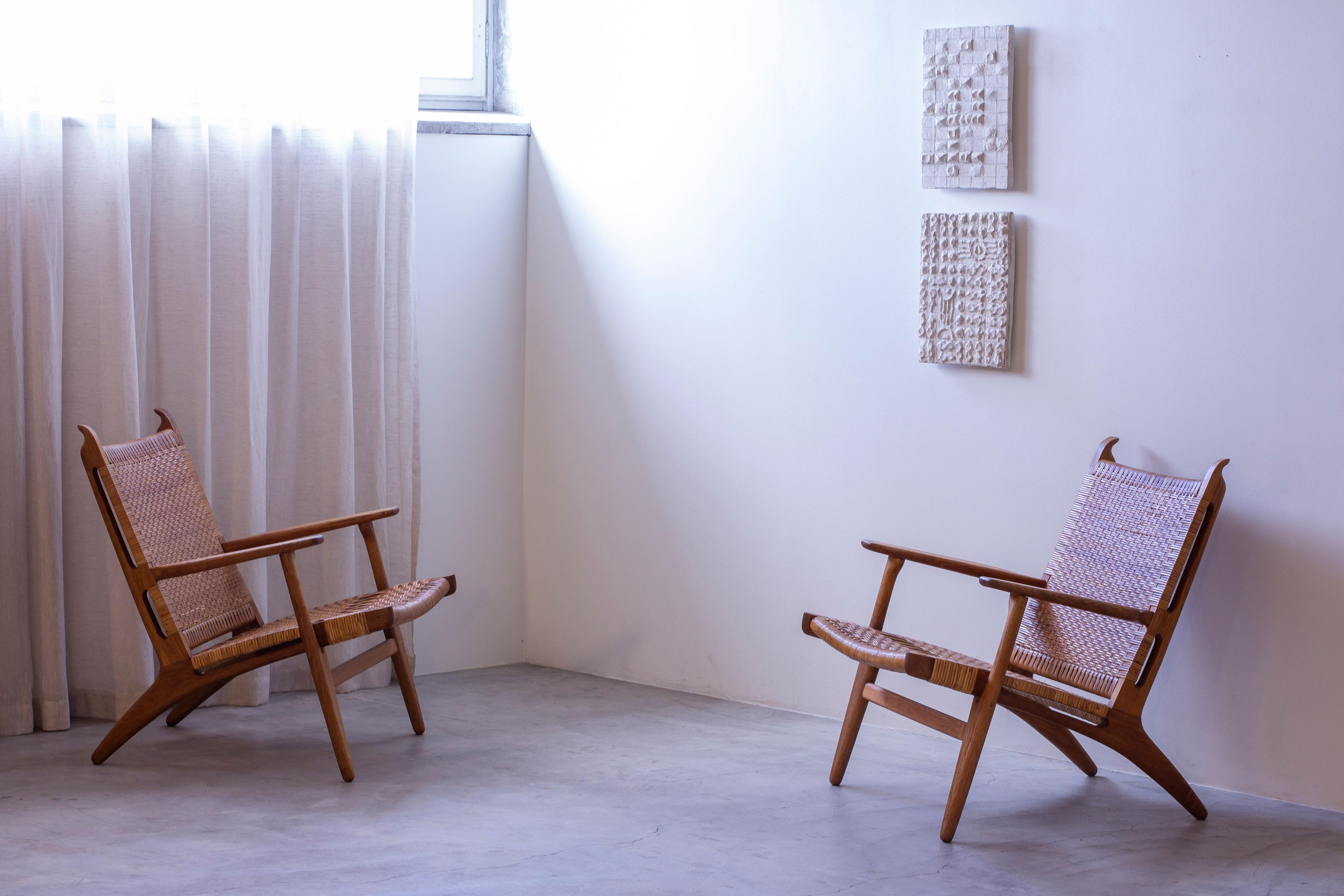 Pair of lounge chairs model CH-27 designed by Hans J. Wegner. Produced in Denmark by Carl Hansen & Søn during the 1950s. Made from solid oak with cane weave seats. Beautiful patina and overall very good vintage condition. 

Price for the pair.

Hans