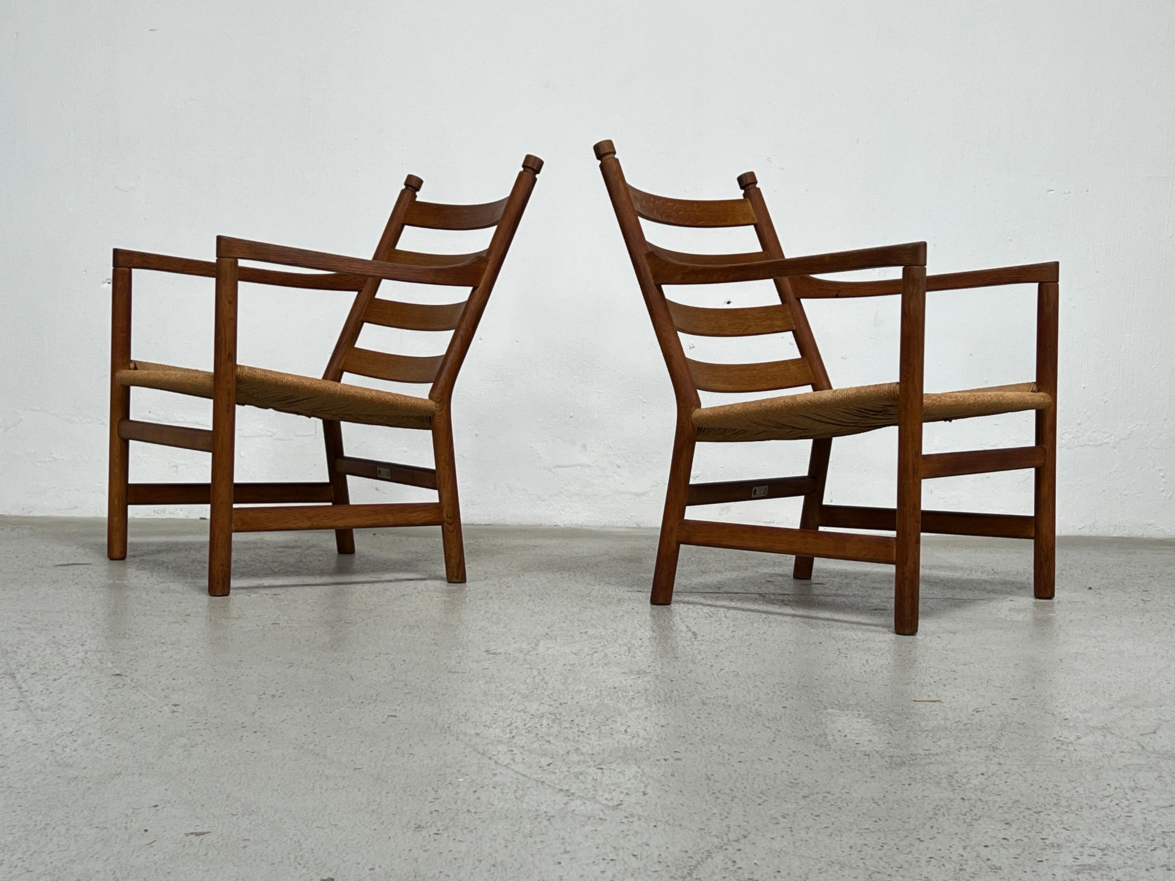 A pair of Oak and rush lounge chairs by Hans Wegner for Carl Hansen. 
Two pairs available. 