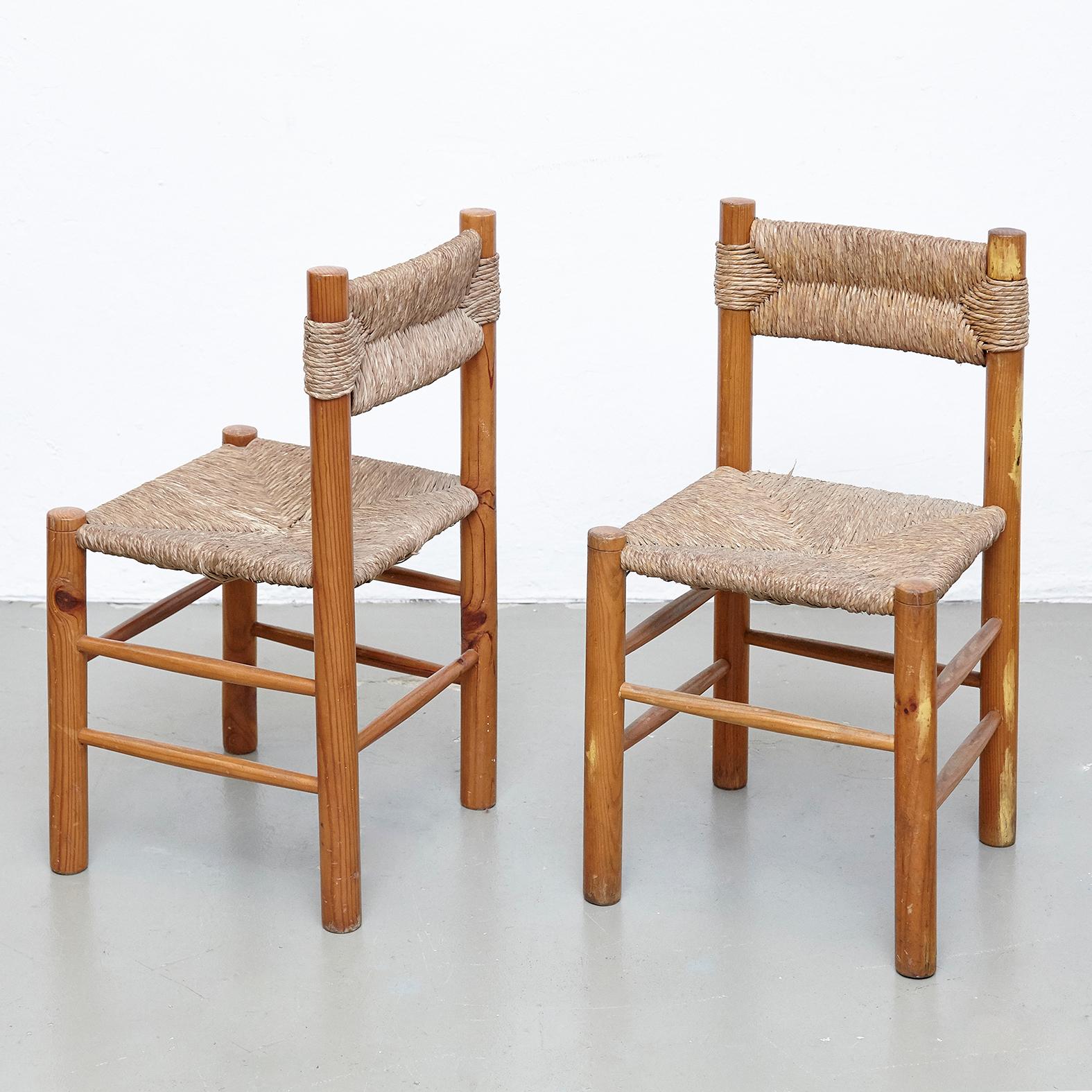 Chairs designed in the style of Charlotte Perriand, made by unknown manufacturer.

Wood and rattan.

In good original condition, with minor wear consistent with age and use, preserving a beautiful patina.