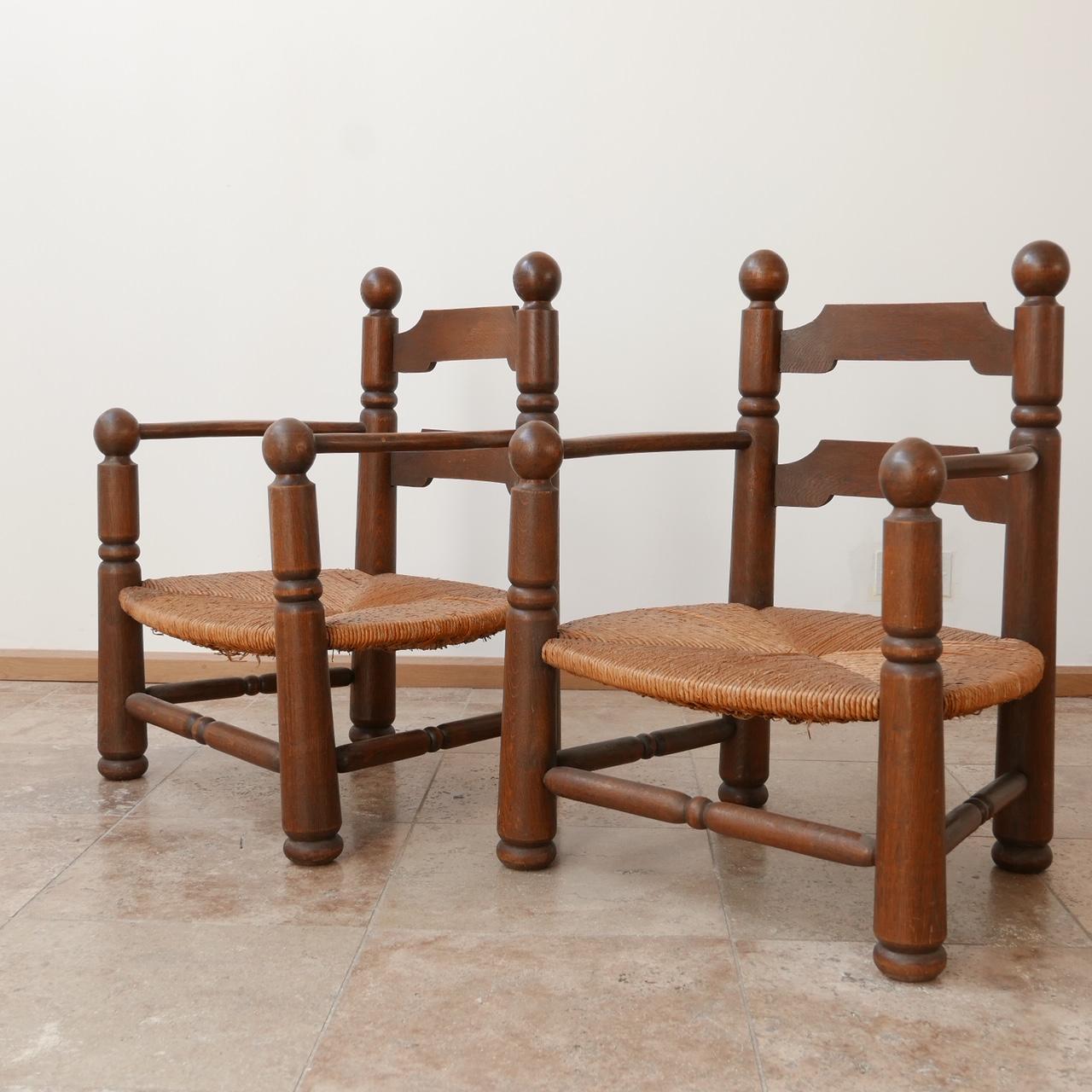A pair of circa 1940, French low chairs attributed to Charles Dudouyt. 

Rush seats, with a sturdy oak frame. 

Heavy chairs indicative of their quality.

Ideal either side of a fire place, in a bedroom or hallway. 

Dimensions: 57 W x 50 D