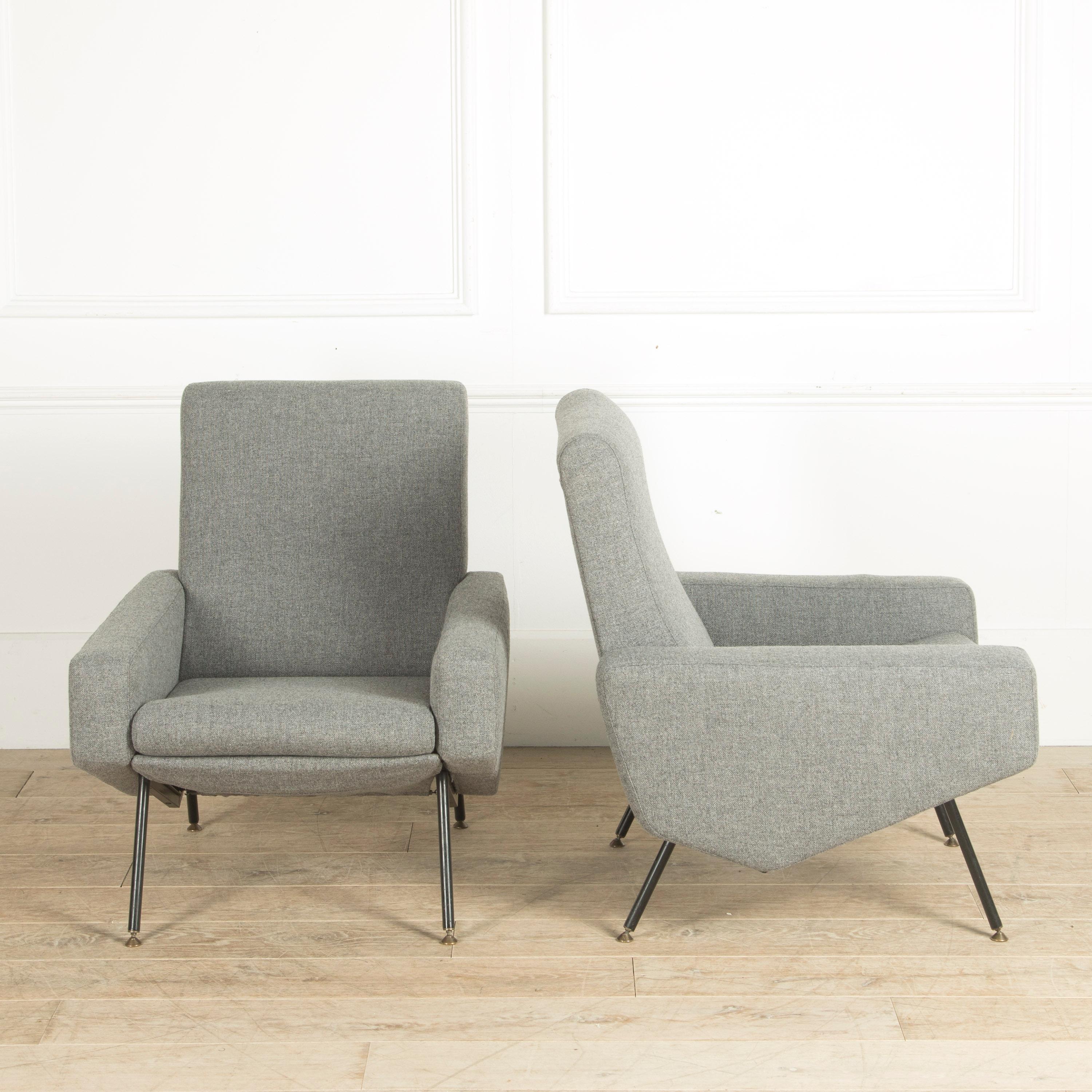 A freshly re-upholstered pair of armchairs designed by Paul Geoffroy and Pierre Guariche for Airborne. French, circa 1960. Legs in lacquered metal with brass feet.