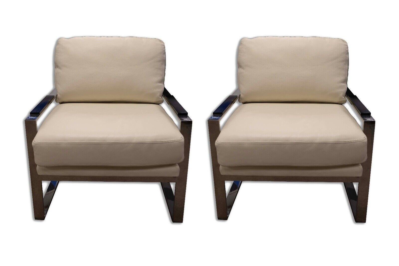 Presented is a pair of Cy Mann style chairs, part of the Modernism Michael Weiss Collection by Vanguard Furniture. These chairs boast a contemporary design with a sleek combination of off white upholstery and dark, angular wooden arm rests. The