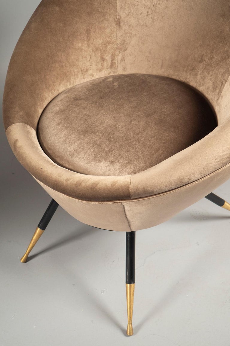 Over-upholstered comfortable rounded back and seat, raised on four tapered, out-splayed legs in black steel ending in brass sabots.

Measures: Height 34.25”, width 30”, depth 30”
Seat: 19”.
 