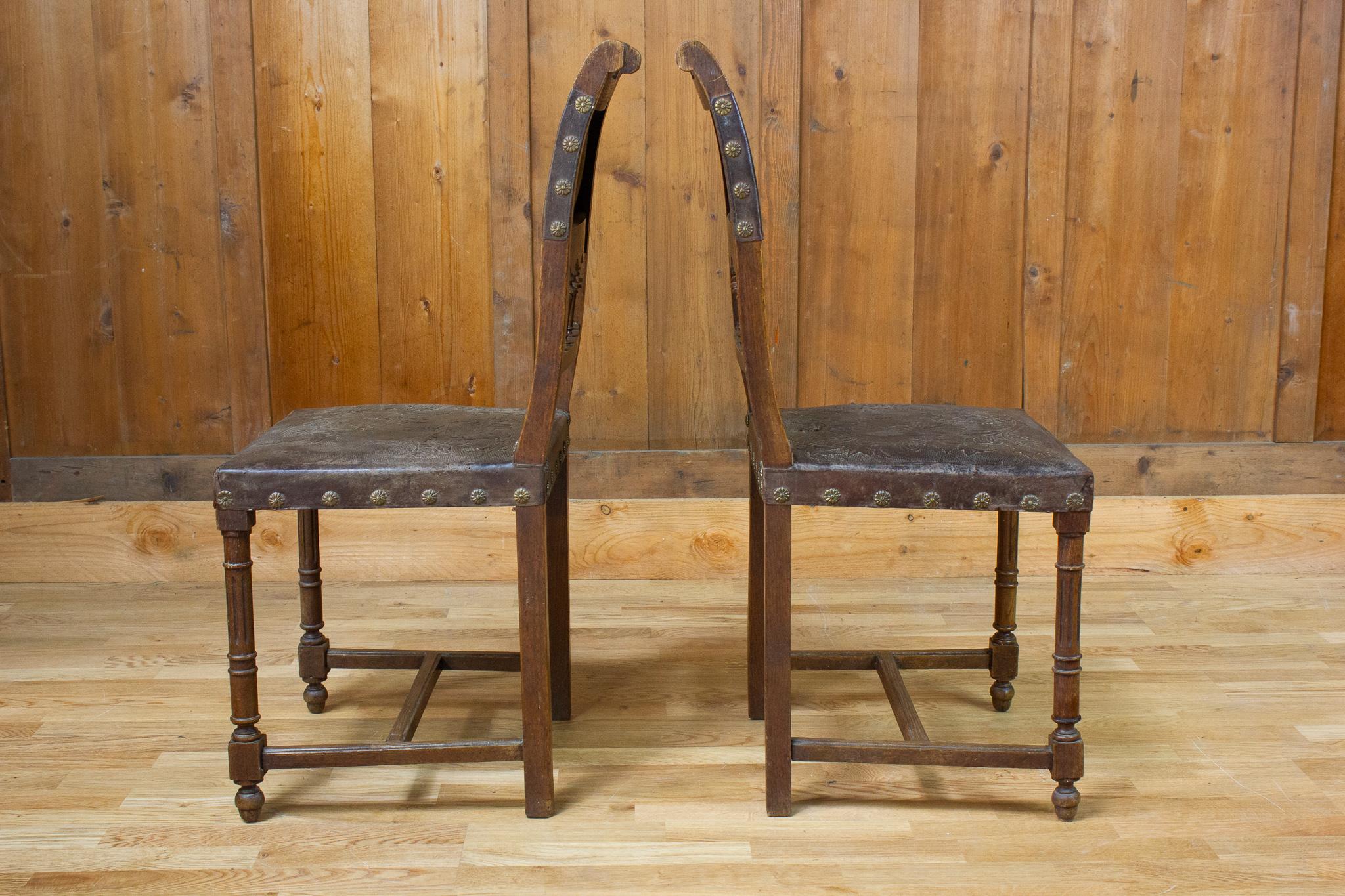 Elegante coppia di sedie in stile neorinascimentale o HENRY II in pelle e legno risalenti al XIX secolo. La struttura in legno è intagliata con flauti e volute. Part A in pelle formano parte dello schienale e della seduta. La pelle forma dei motivi