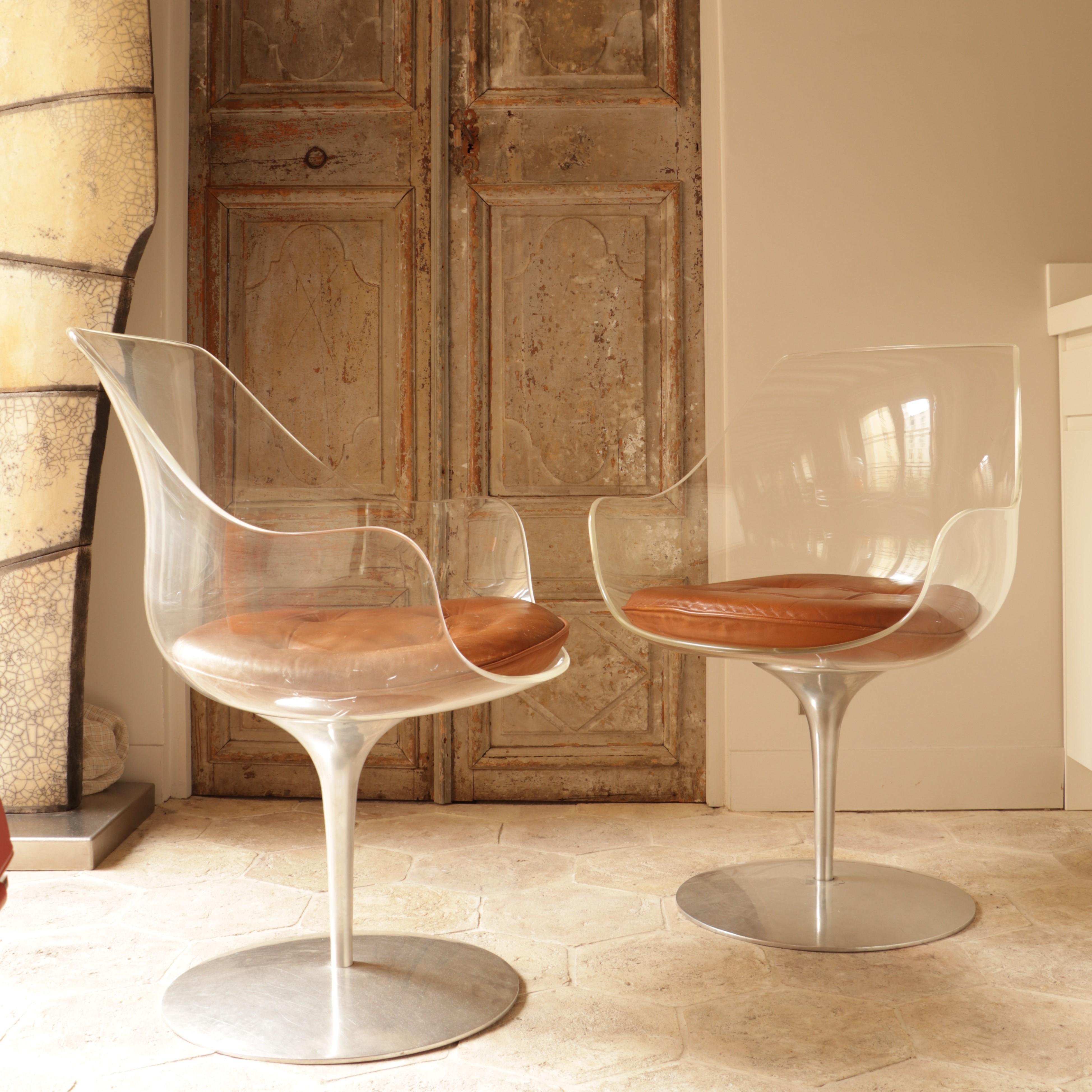 These two champagne chairs are made of plexiglass and steel and have brown leather cushions.
They were made by Estelle and Erwin Laverne in the 1960s.
Erwine Laverne studied in the United States and then in Europe from 1928. In 1934, he met