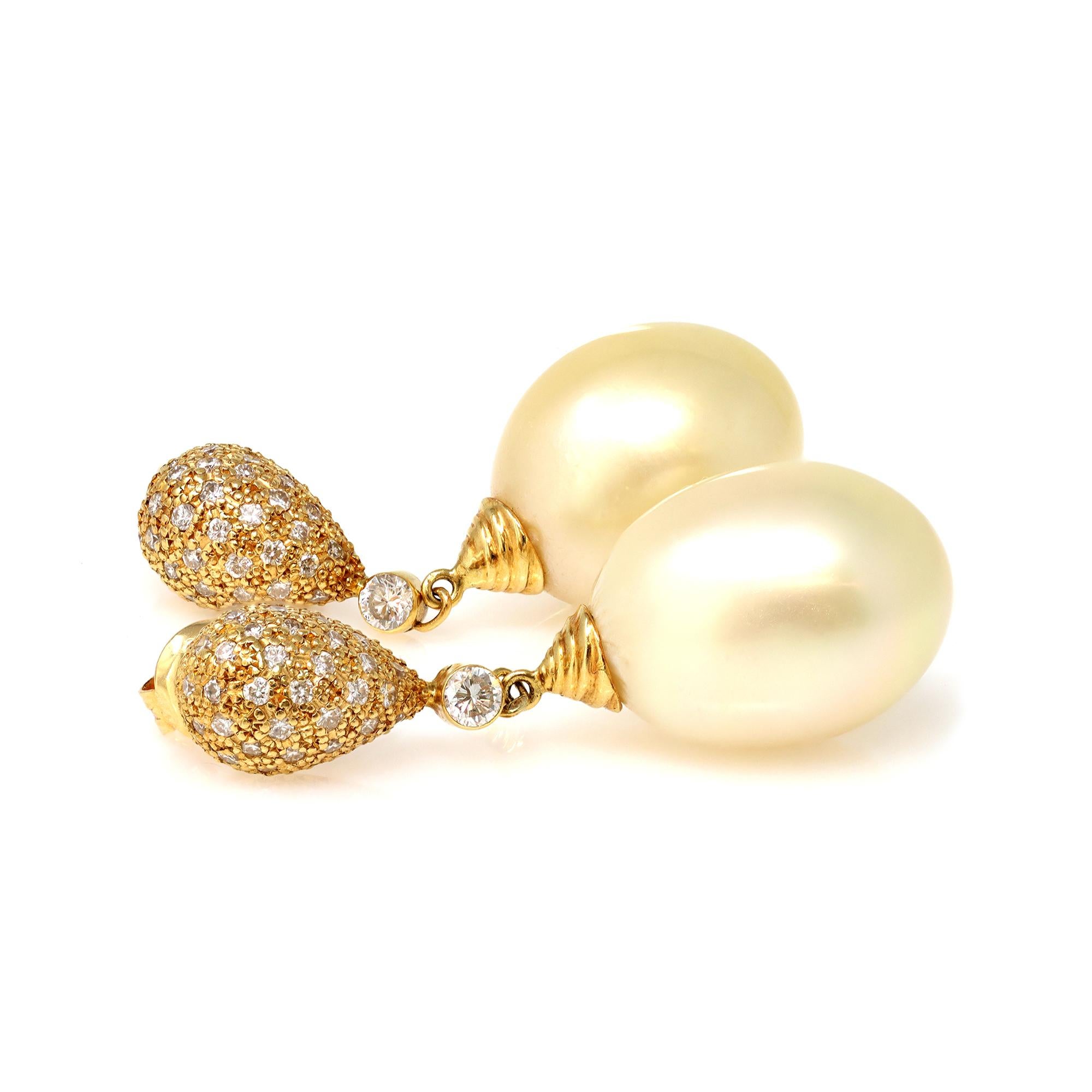 A pair of vintage South Sea Pearl and Diamond dangling earrings in 18K yellow gold, circa 1980. The big size cultured pearls are 15 millimiter, they are drop shape natural Champagne color with very minor surface inclusions with a soft sheen luster.