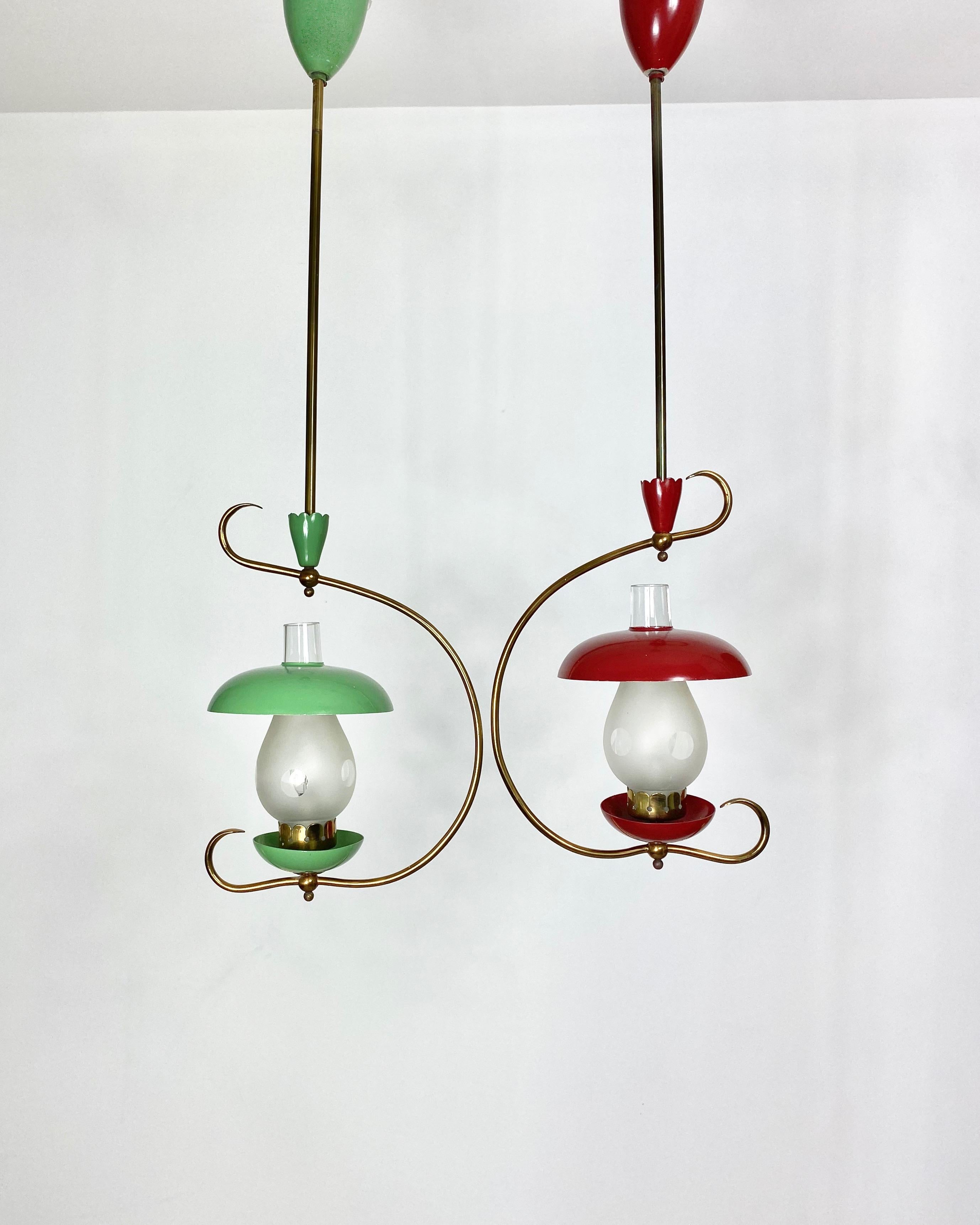 Paire de deux lustres suspendus en métal et laiton, en forme de deux champignons, vert et rouge. Les abat-jour qui ressemblent à la tige sont en verre. Italie, vers 1950.