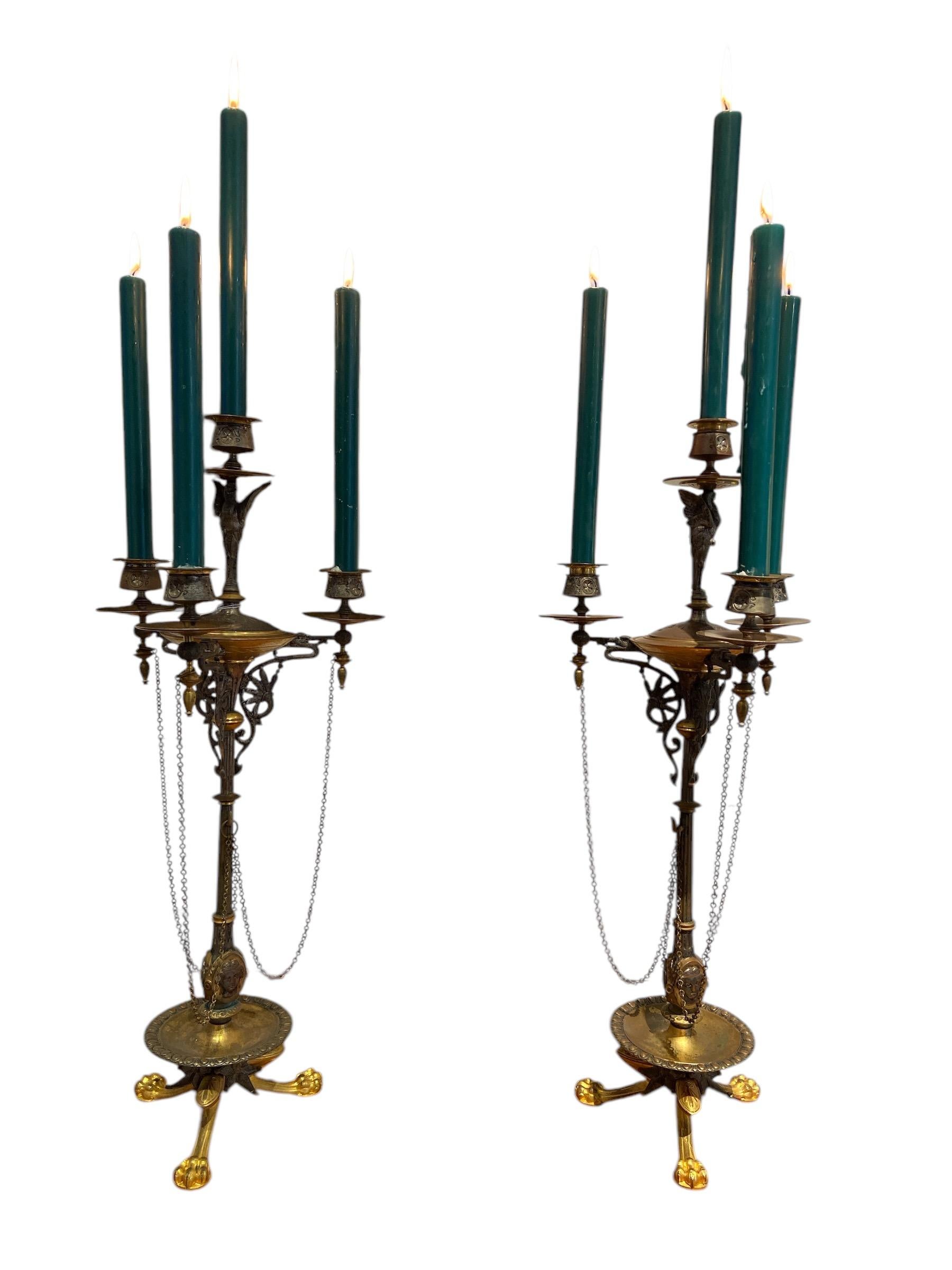 Coppia di candelabri in stile impero in bronzo, parzialmente dorati, decorati con 
uccelli, artigli, catene, motivi floreali e maschere. Con 4 portacandele ciascuno. 