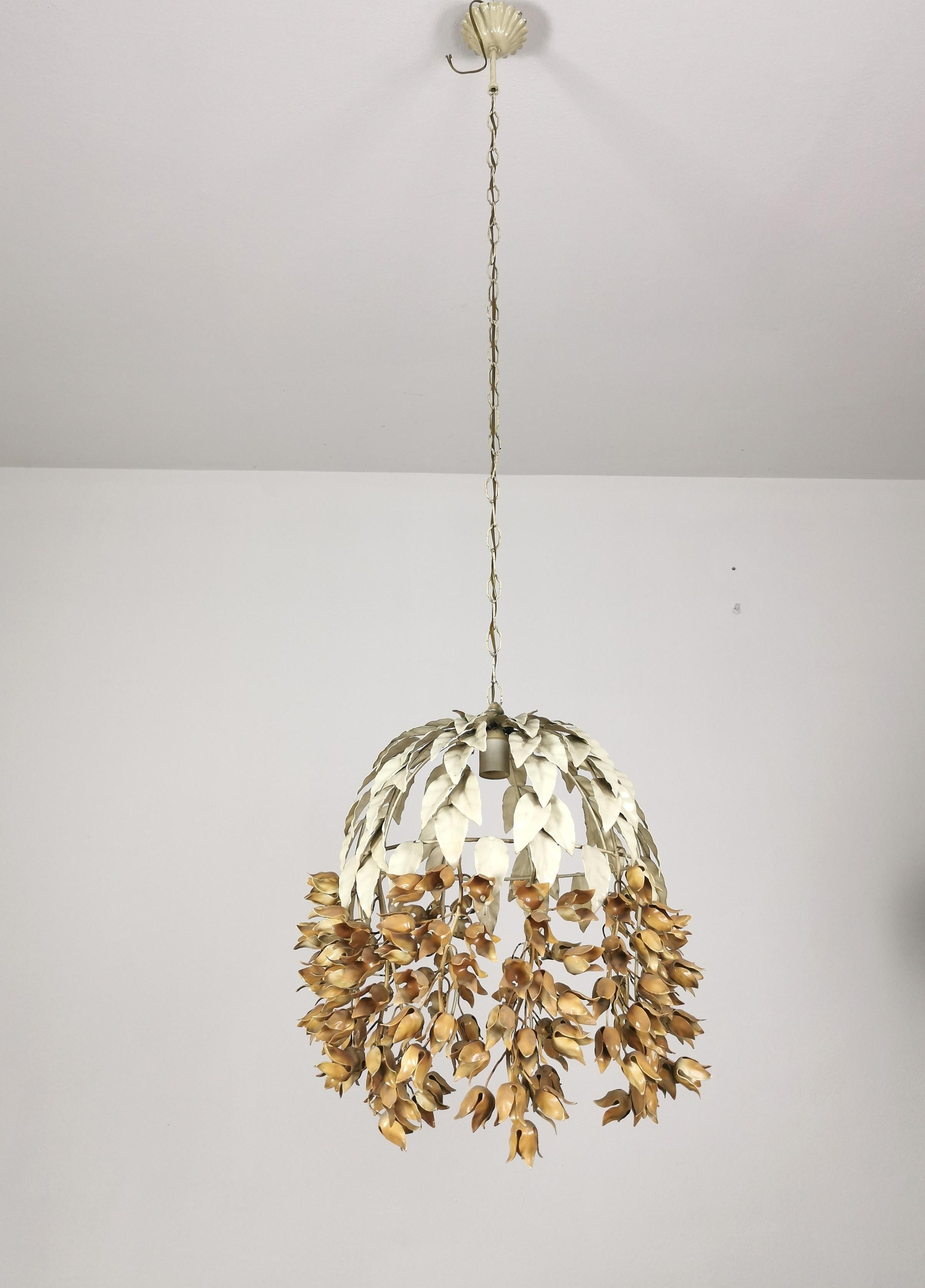 Paire de lampes à suspension de différentes hauteurs produites en Italie dans les années 1960. Chaque suspension individuelle est faite de métal émaillé avec des décorations de feuilles dans la partie supérieure et des décorations de fleurs séchées
