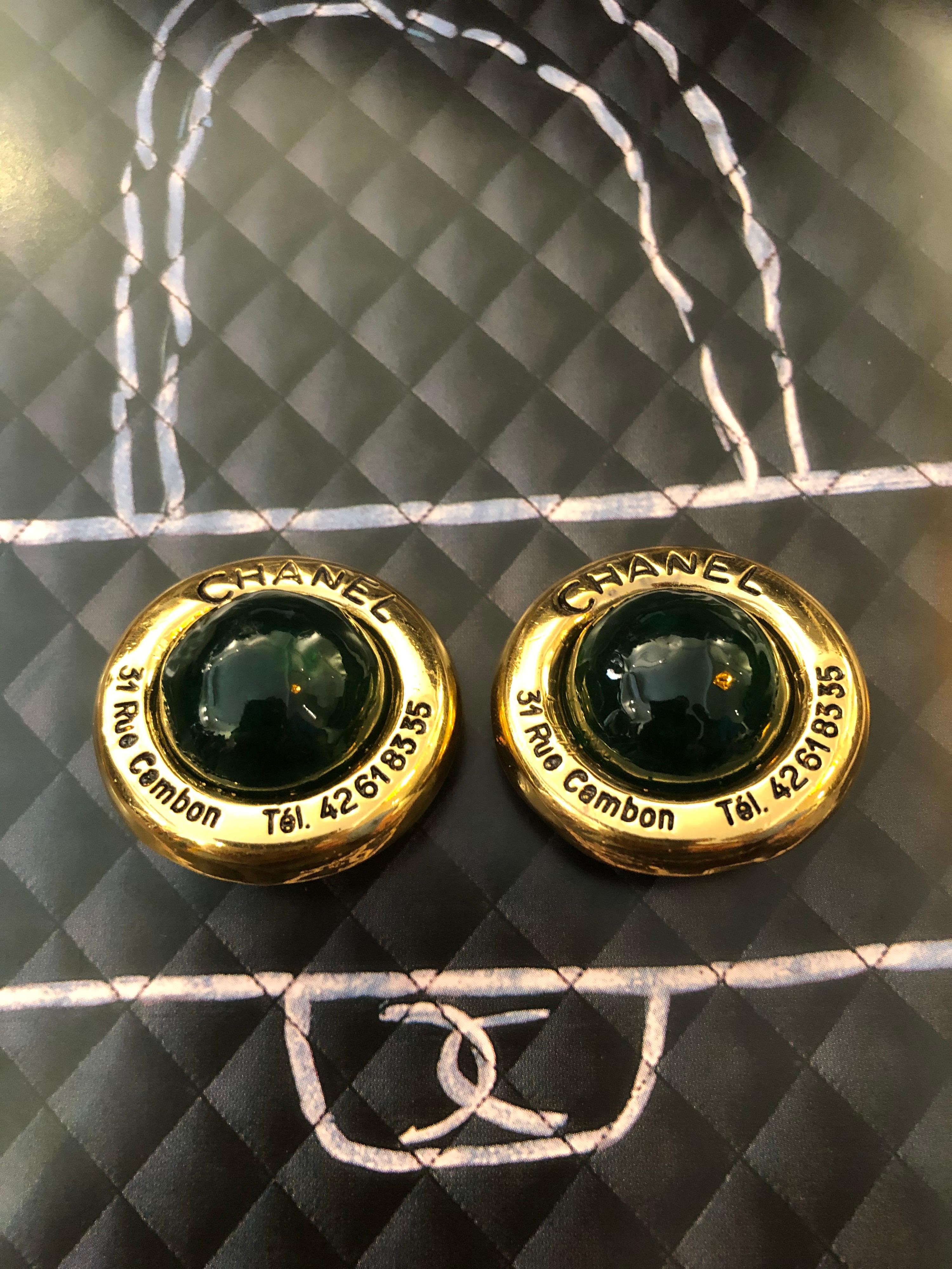 These 1970s Chanel gold toned Cambon earclips are crafted of gold toned metal featuring a green gripoix hemisphere. Measures approximately 3.5 cm. Stamped CHANEL. Clip on style.

Condition: Minor signs of wear. Generally in very good condition