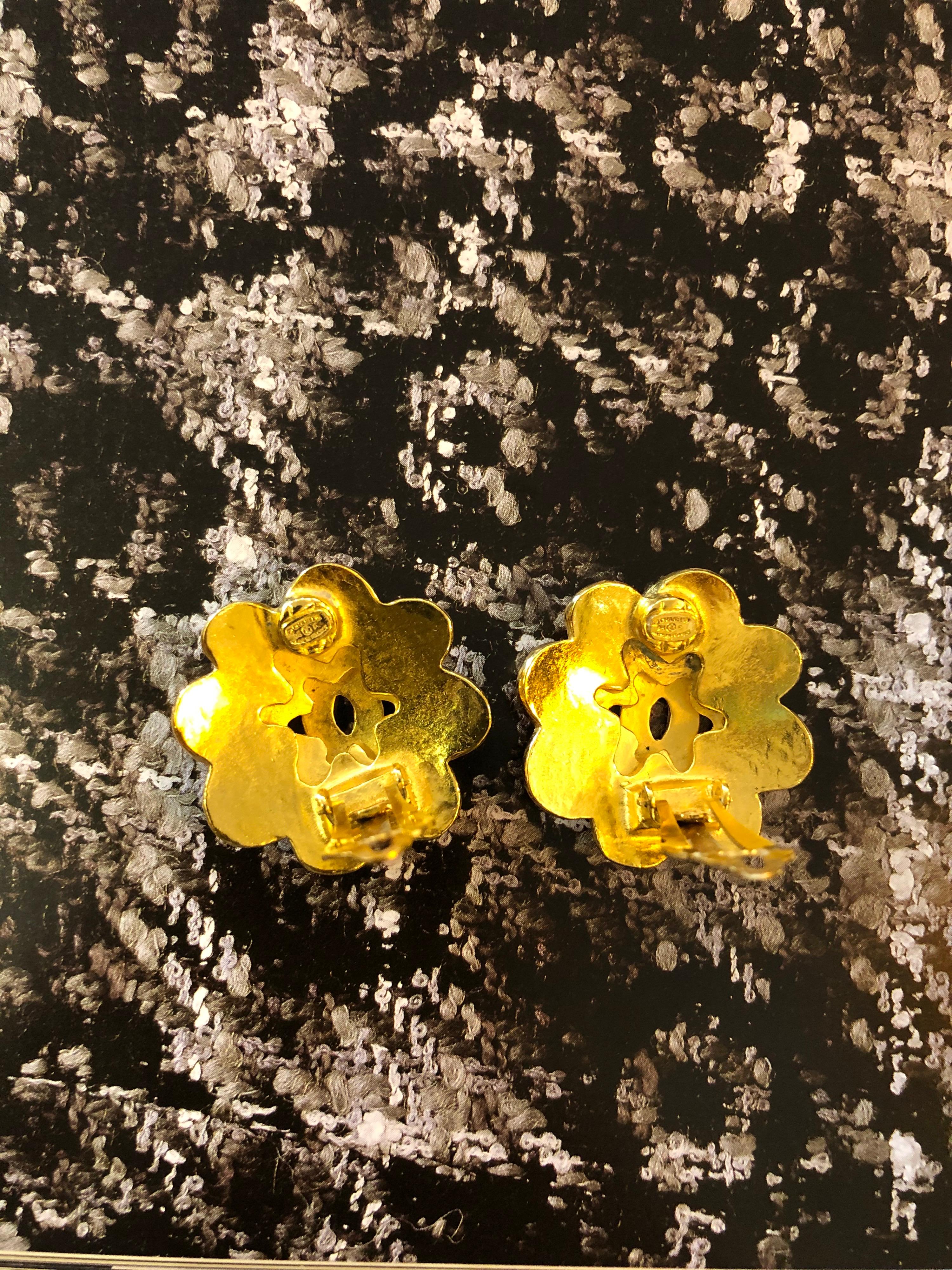 Pair of 1990s Chanel gold toned earclips featuring two camellia layers with a centered CC logo. Stamped Chanel 96P, made in France. Measures approximately 3cm. Clip in style. Come with box. 

Condition: Signs of wear consistent with age and normal