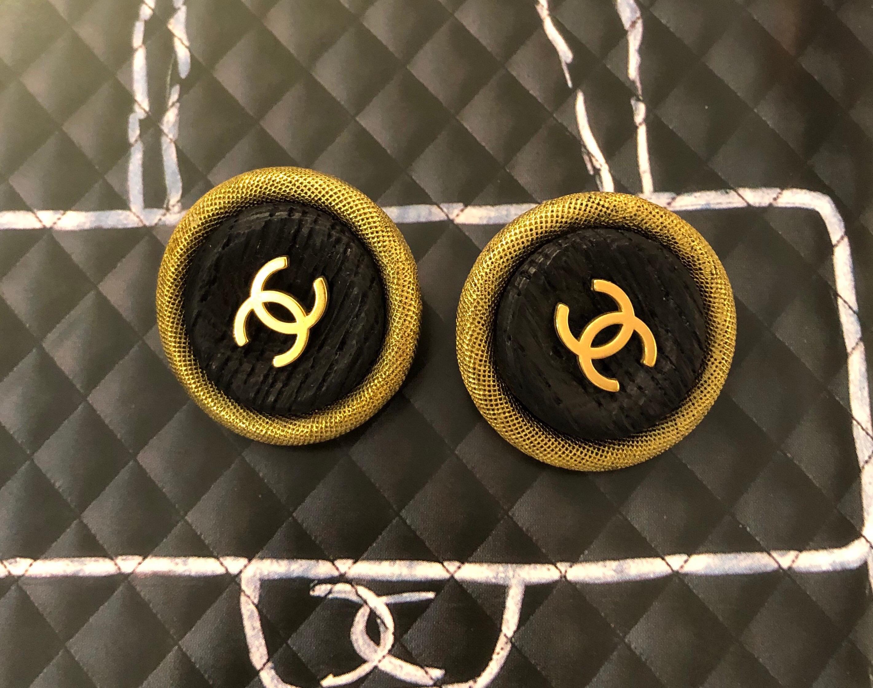These 1994 vintage Chanel jumbo earclips are crafted of gold toned metal featuring a wood-textured resin base decorated with a gold toned CC at the centre. Measure approximately 3.5 cm. Stamped Chanel 94P, made in France. Come with box. 

Condition: