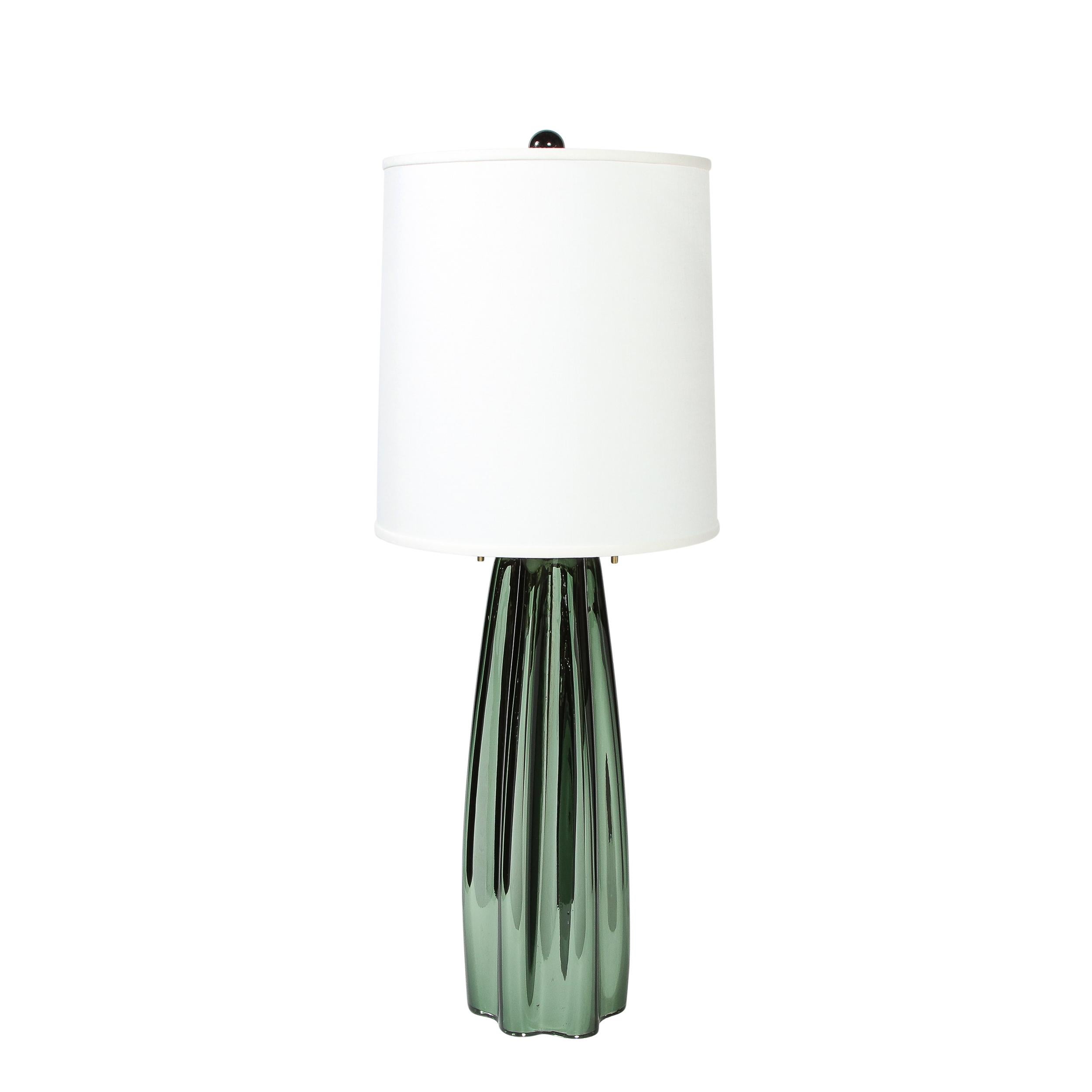 This stunning pair of modernist table lamps were realized in Murano, Italy- the island off the coast of Venice renowned for centuries for its superlative glass production. They feature channel form bodies with scalloped bodies in iridescent viridian