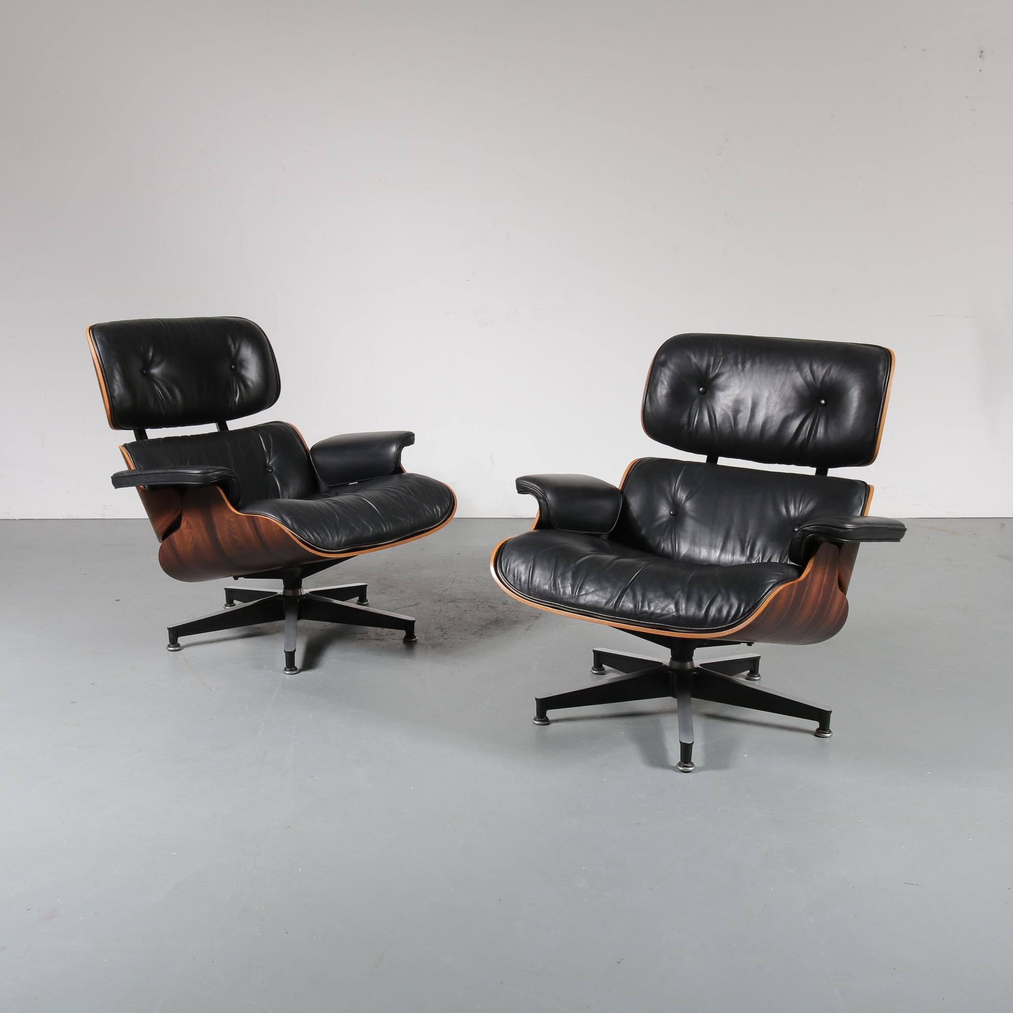 A pair of very rare and much sought after pair of lounge chairs designed by Charles and Ray Eames, manufactured by Herman Miller, circa 1970.

They are made of high quality deep brown tropical hardwood with black leather upholstery, a beautiful