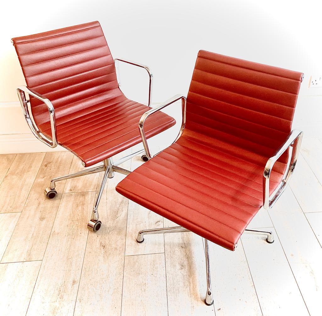 Great pair of Charles and Ray Eames Aluminium group office chairs in red leather made under licence by ICF, circa 2010.

Really used condition, very minimal signs of usage. One of the of the two chairs has castors and the other has glider feet