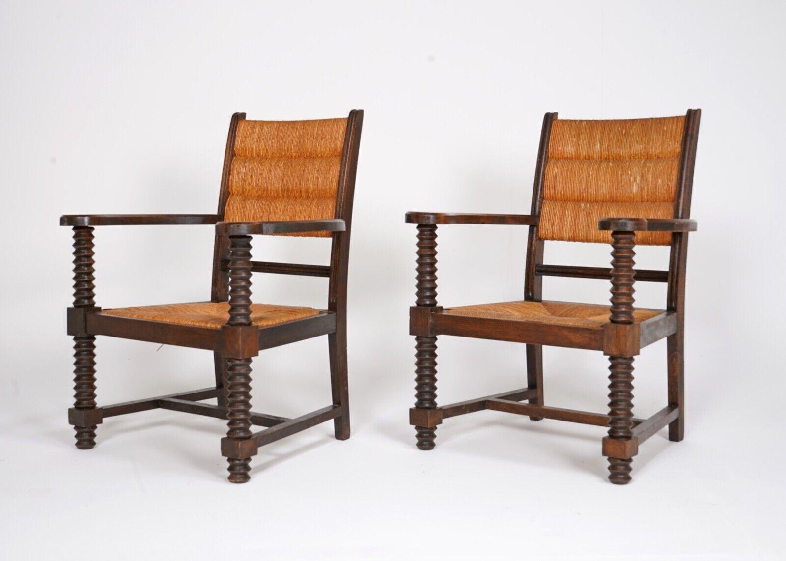 A pair of early 20th century Charles Dudouyt armchairs with rush seat and back, with his trade mark bobbin turned legs and arms. France circa 1940s.

In good condition for age - please carefully look over all images for closer details.