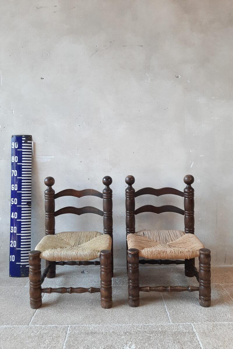 Pair of Finca style chairs by Charles Dudouyt. Small fire side chairs with beautiful carved oak frames and rationalist style wicker upholstery. Midcentury 1940s. 

As you can see on the photos the wicker is a bit worn.

Measures: H 70 x W 46 x D