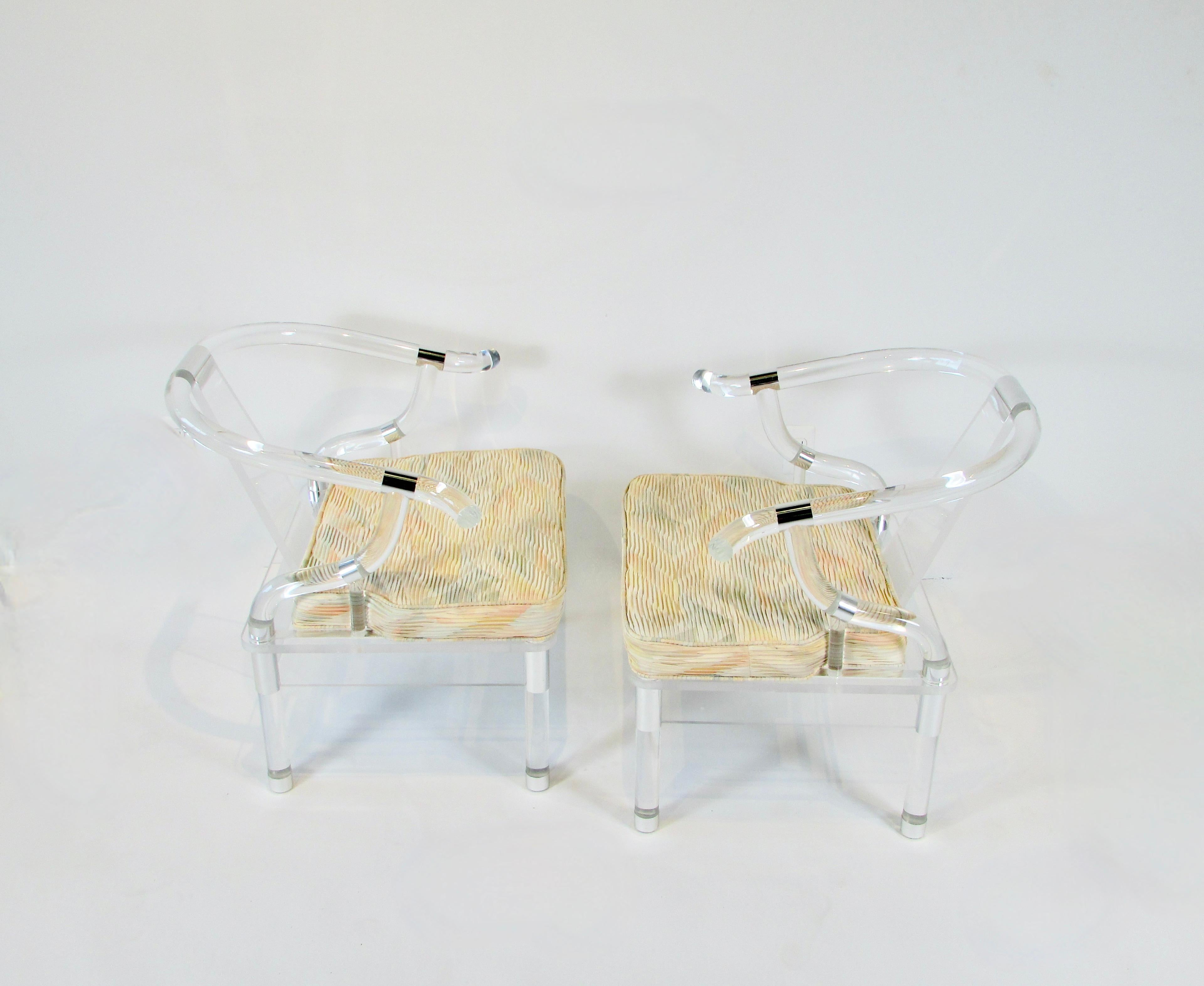 Pair of beautifully proportioned lucite armchairs . So much in the style of Charles Hollis Jones the master of mating acrylics with chrome .one and a quarter inch thick lucite legs support lucite platform holding the seat cushion . The same thick