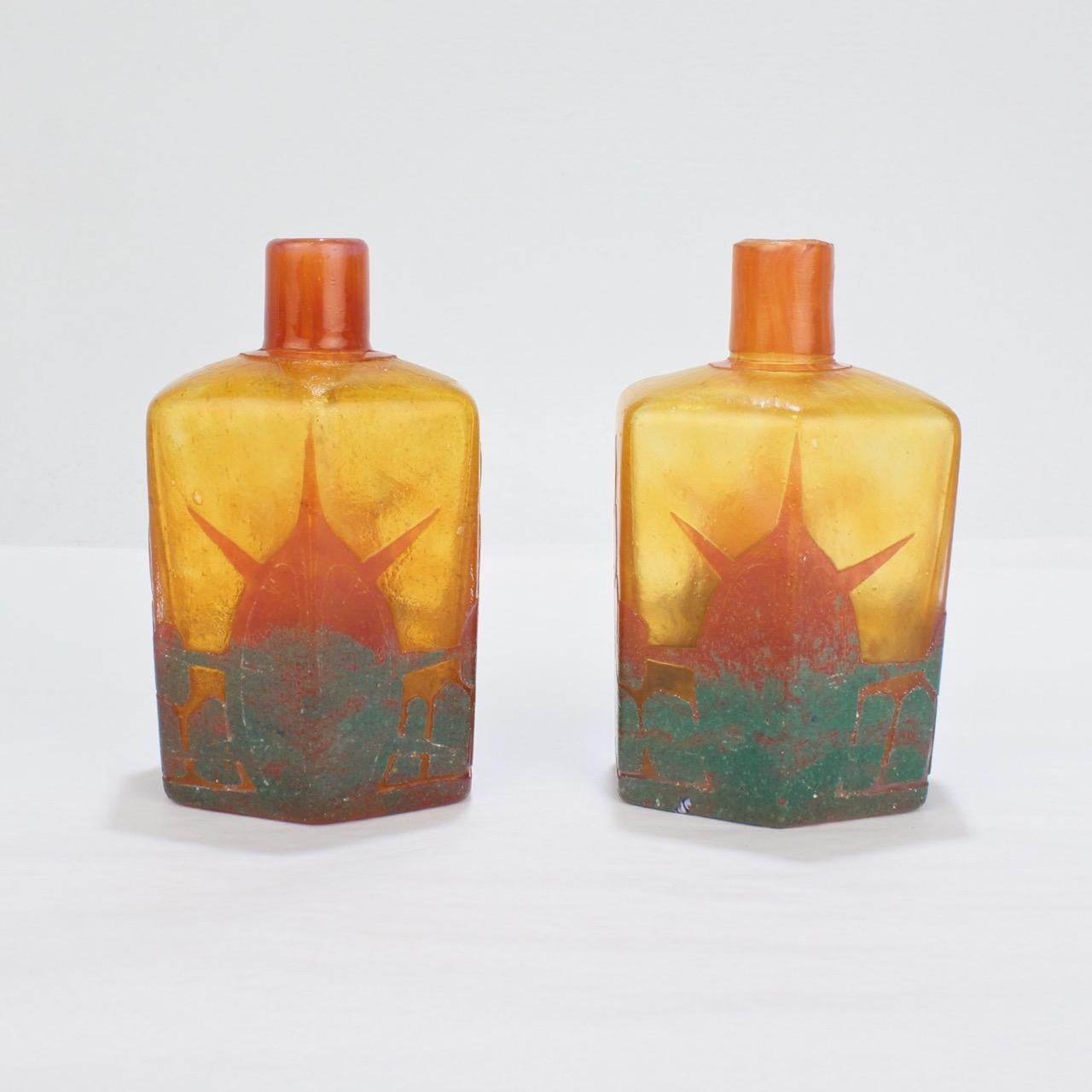 A fine matched pair of Charles Schneider (or Charder Le Verre Francais) French art glass bottles.

Each cut with what appears to be a stylized rising sun or daybreak scene in orange, red, and green tones.

The bases each have a 'candy cane'