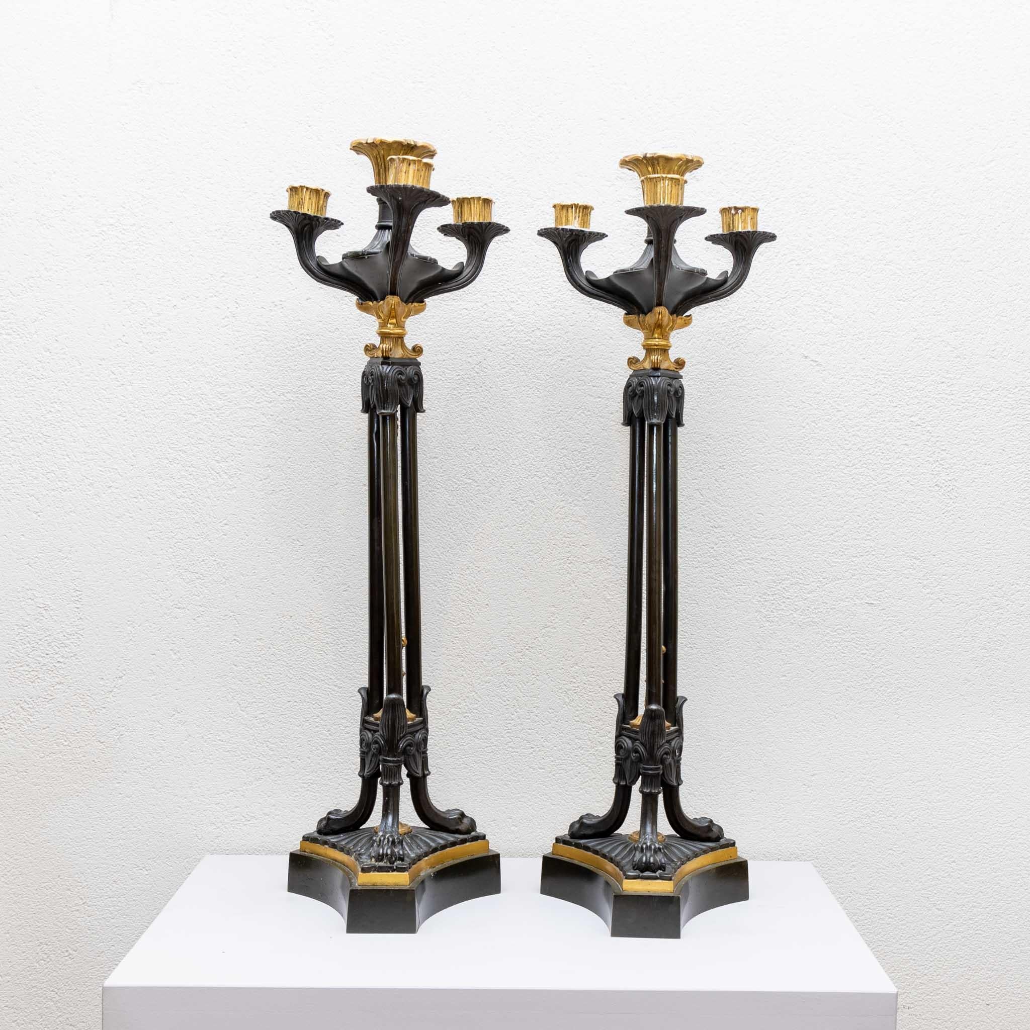 Pair of beautiful fire-gilt and painted candlesticks on a three-pass stand and three candle arms with removable spouts. A fantastic and original patina.