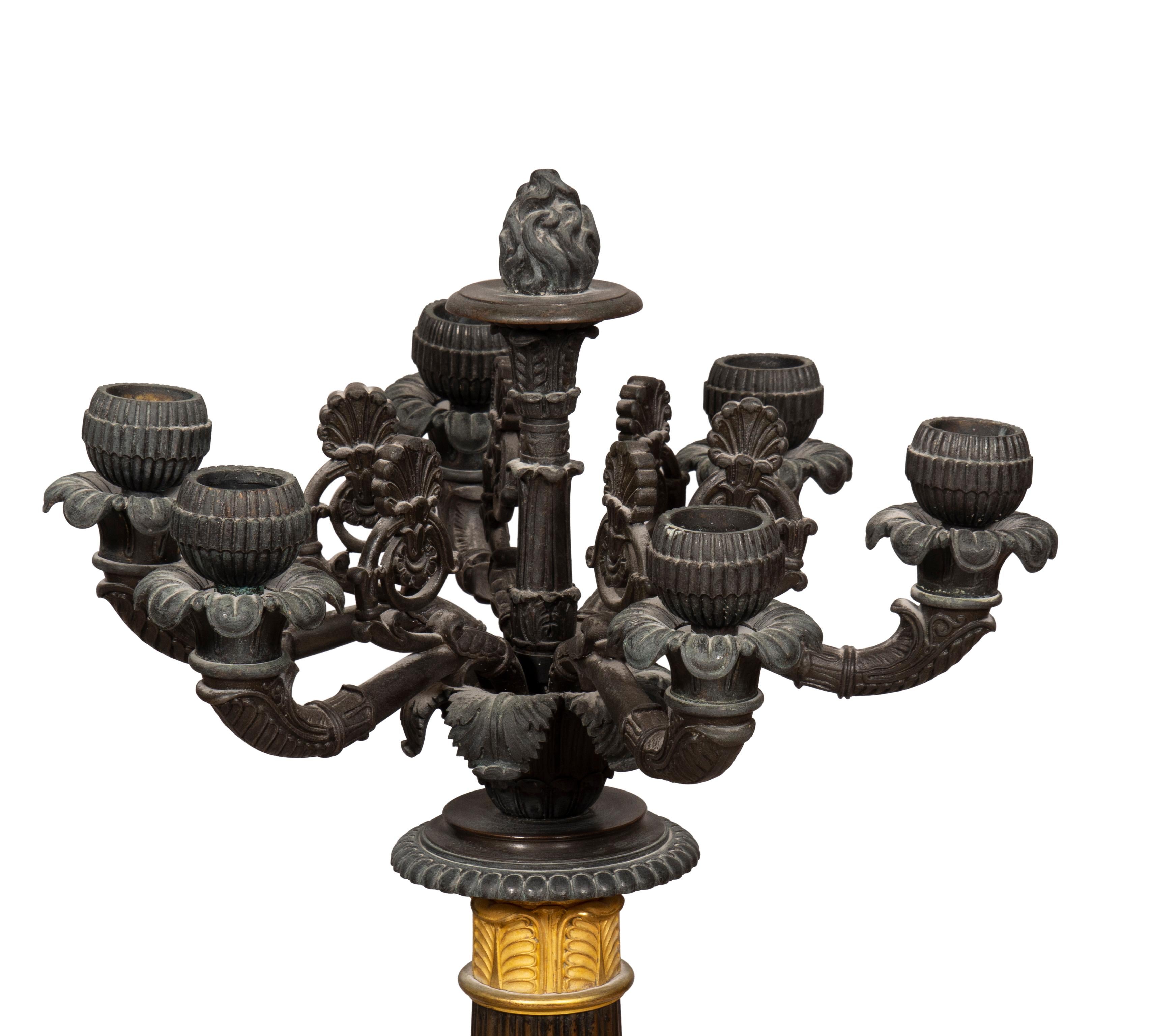 With six candle arms joining a reeded column seated on a square plinth with dolphin mounts on the corners. Removed from 