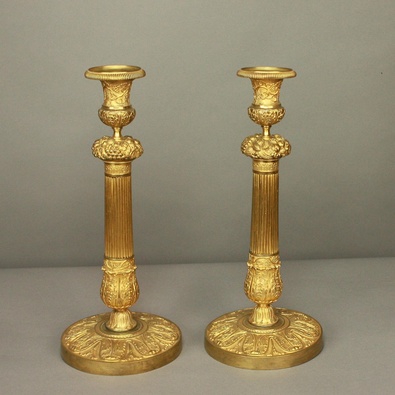 Pair of French Early 19th Century Charles X Gilt-Bronze Candlesticks, circa 1825

Pair of late Empire / Charles X gilt bronze candlesticks, each with a fluted stem, highlighted on top by a basket of flowers and finely chased foliate on the bottom of
