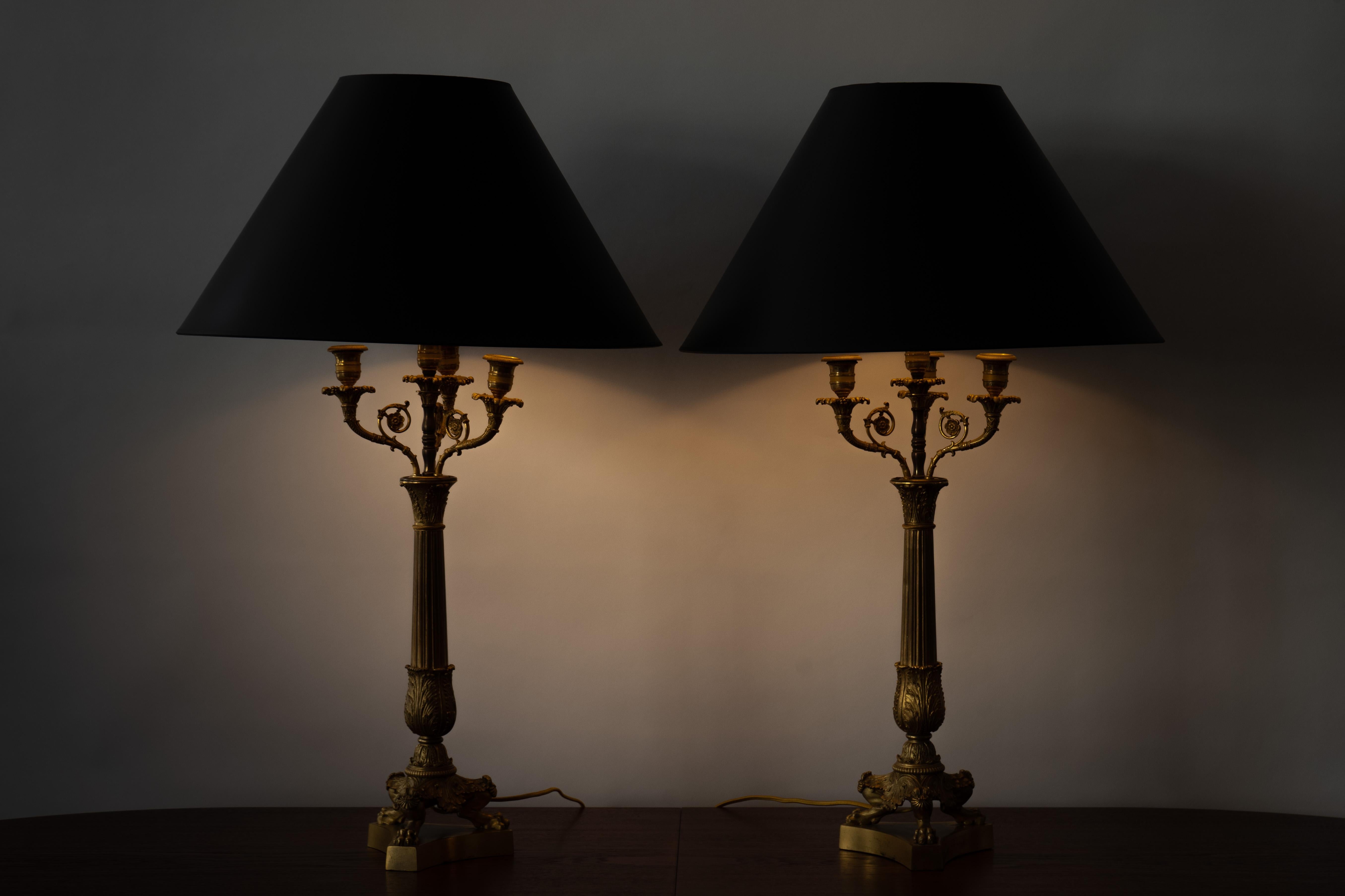 Frankreich, ca. frühes 19. Jahrhundert. Ein feines Paar Charles X elektrifizierte Kandelaber Tischlampen. Jedes Stück ist aus vergoldeter Bronze gefertigt und hat eine zentrale kannelierte Säule auf einem dreibeinigen Sockel mit Tatzenfüßen.