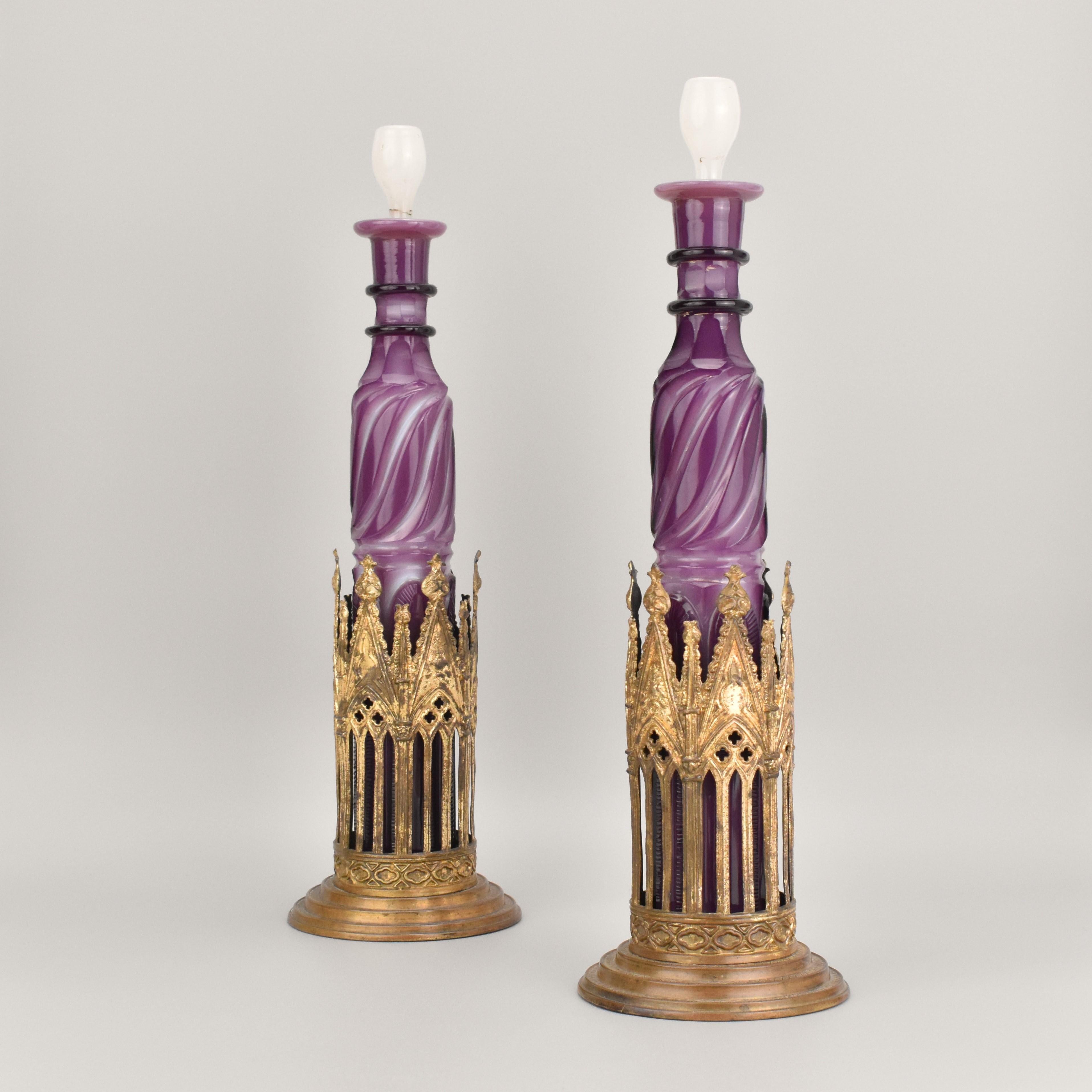 Pair of French Opaline Glass Bottles with Gilt Bronze Stands – Circa 1825

A beautiful pair of opaline glass bottles made from purple and milky white double opal crystal, cut into various shapes around the surface. The bottles are topped with milky