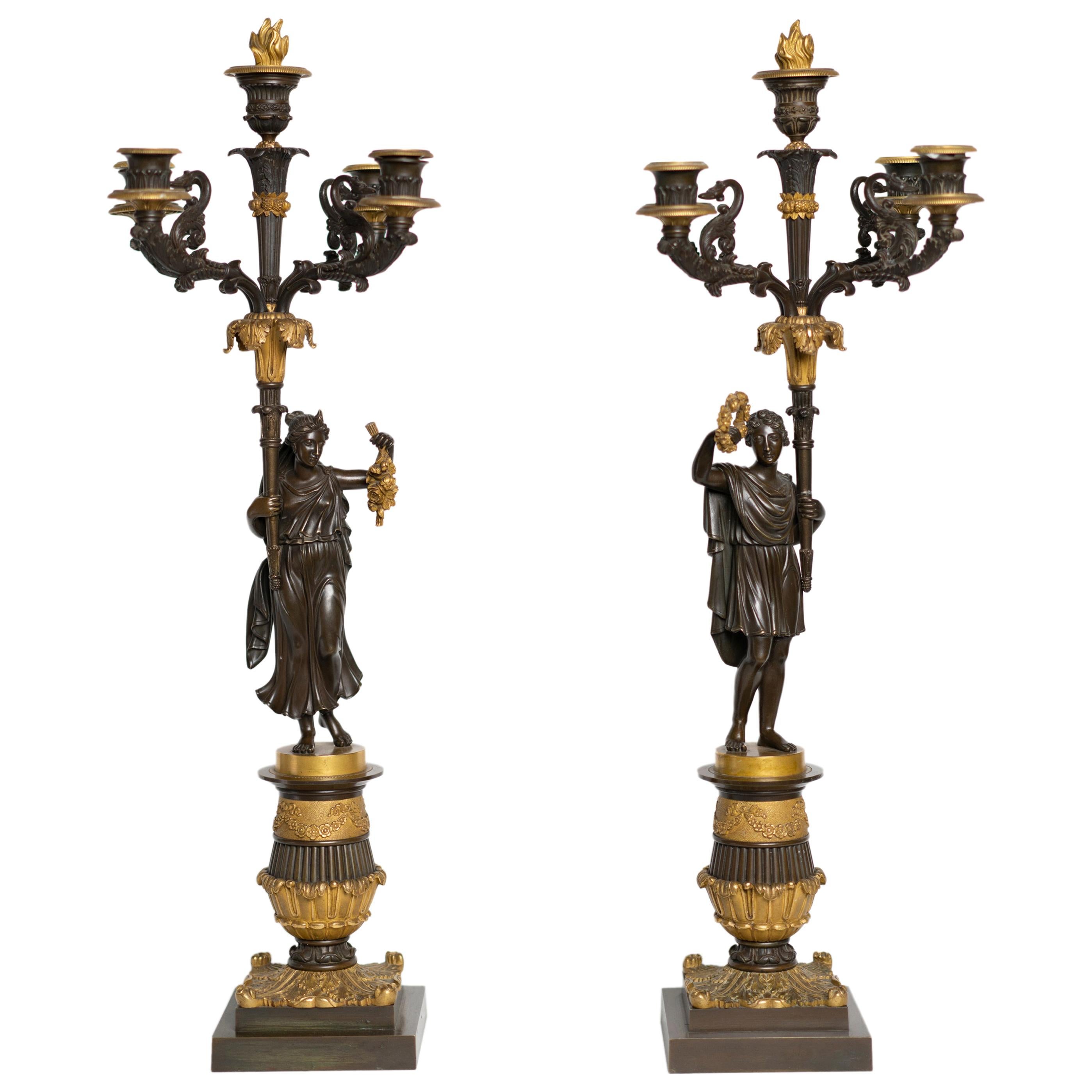Paire de candélabres d'époque Charles X en bronze doré et patiné représentant un couple romain en vente