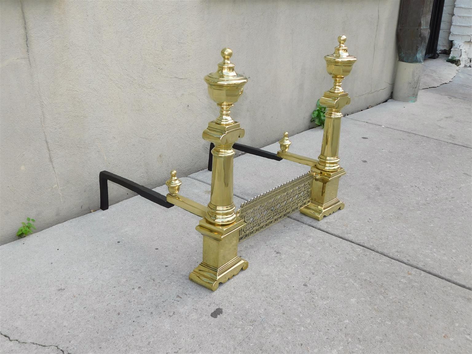 Pair of Rare Charleston Neoclassical brass urn faceted ball finial andirons with the original connecting interior decorative grate, matching log stops, and original rear wrought iron legs, Early 19th century