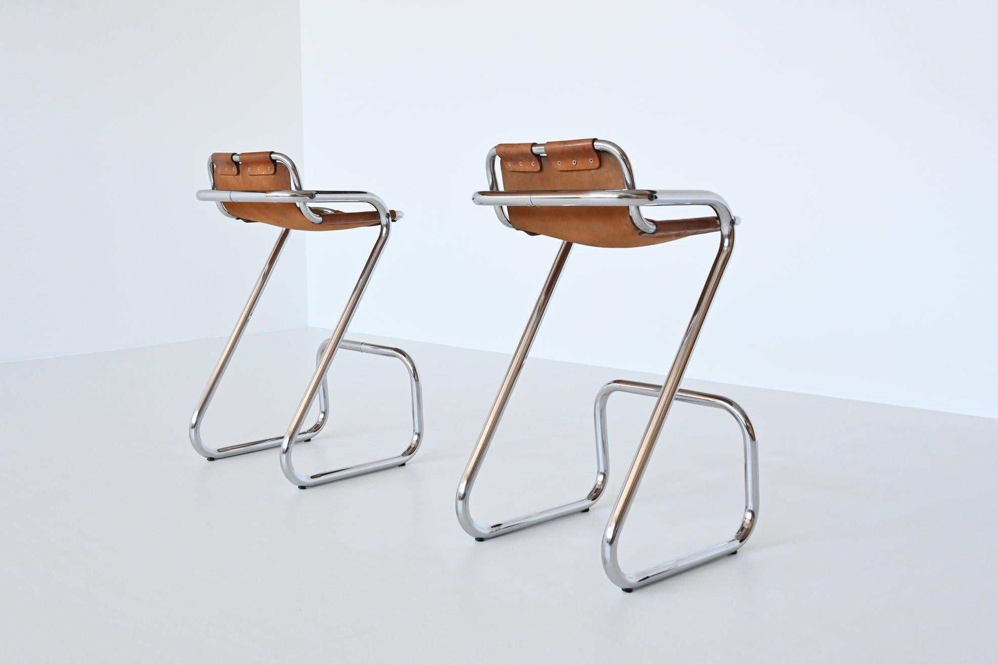 The stools have chrome plated tubular metal frames and thick natural saddle leather seats with a beautiful patina of usage. They are strong, comfortable and look amazing in a kitchen or bar. For sure one of the most popular bar stools around and we