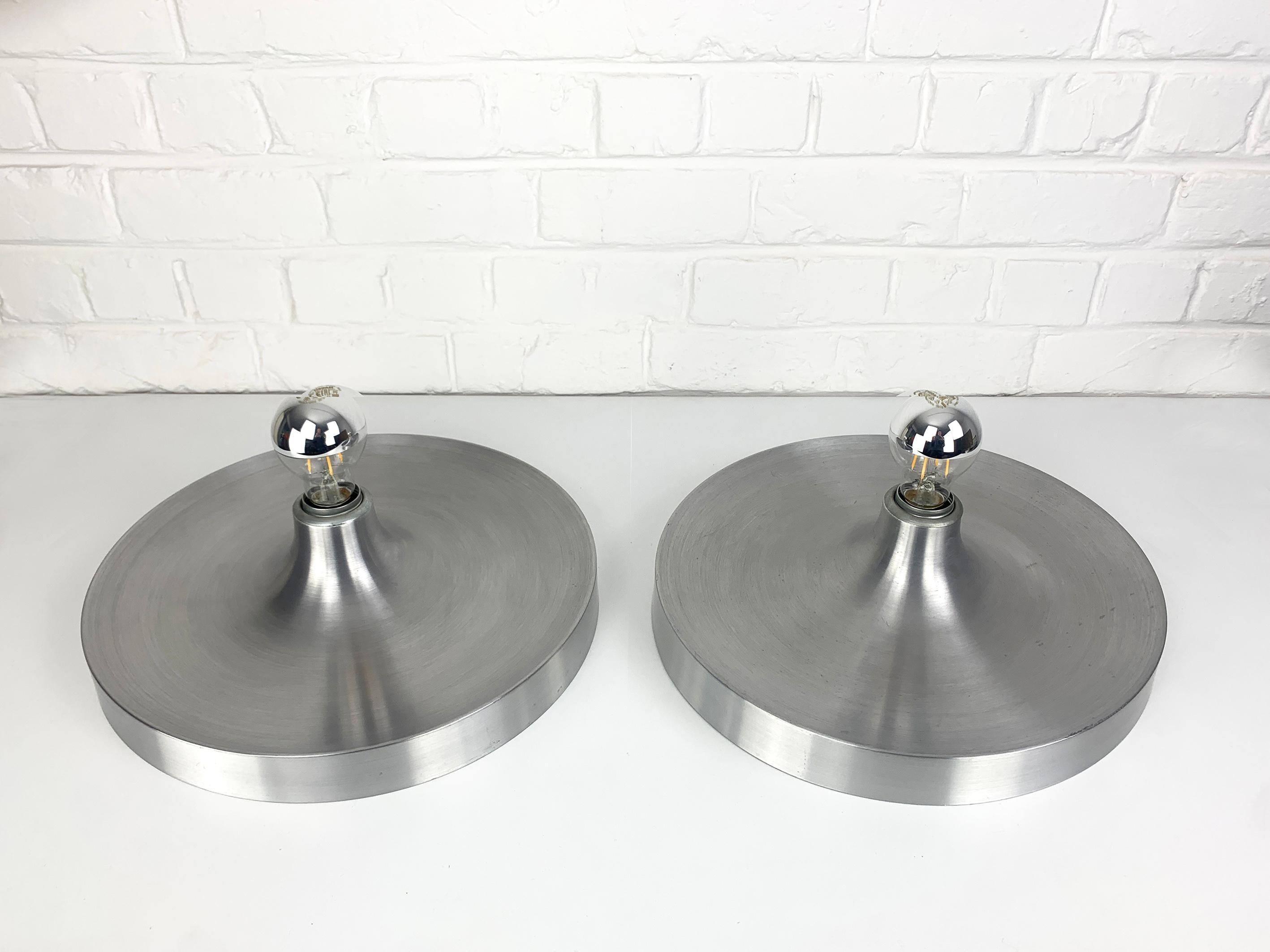 Pair Space Age Flush lights from the 1960s.

These sconces were commissioned / selected by Charlotte Perriand for the interior design of the flats of the 'Les Arcs' and Méribel Ski Resorts in the French Alps.

Diameter 35cm. Brushed aluminium