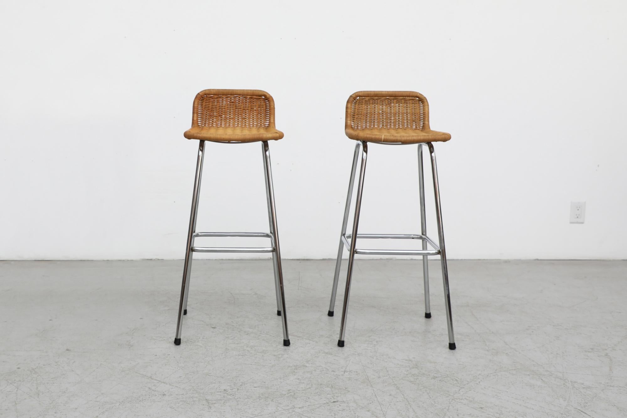 Pair of Charlotte Perriand style rattan bar stools by Dutch designer Dirk van Sliedregt for Rohe Noordwolde with low, rounded seat backs and chrome tubular frames. Seat height is 30