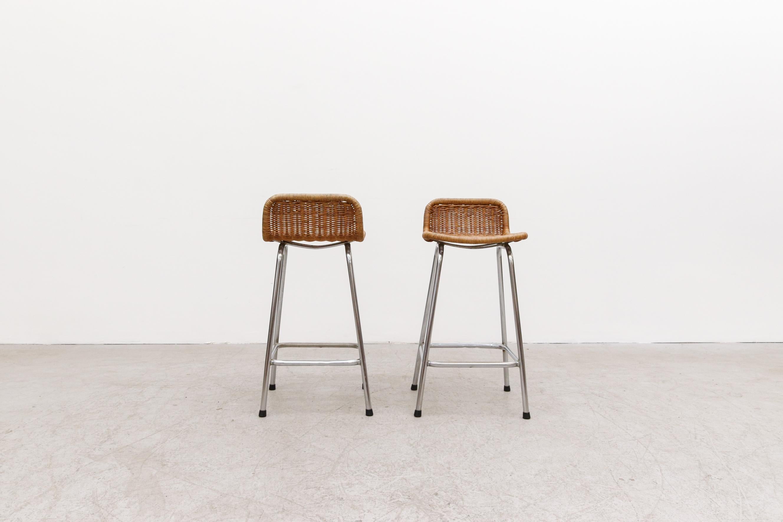 Handsome pair of Charlotte Perriand style wicker bar or counter stools. Minor repairs, otherwise in good original condition. Wear is consistent with its age and use. Seat height is 24