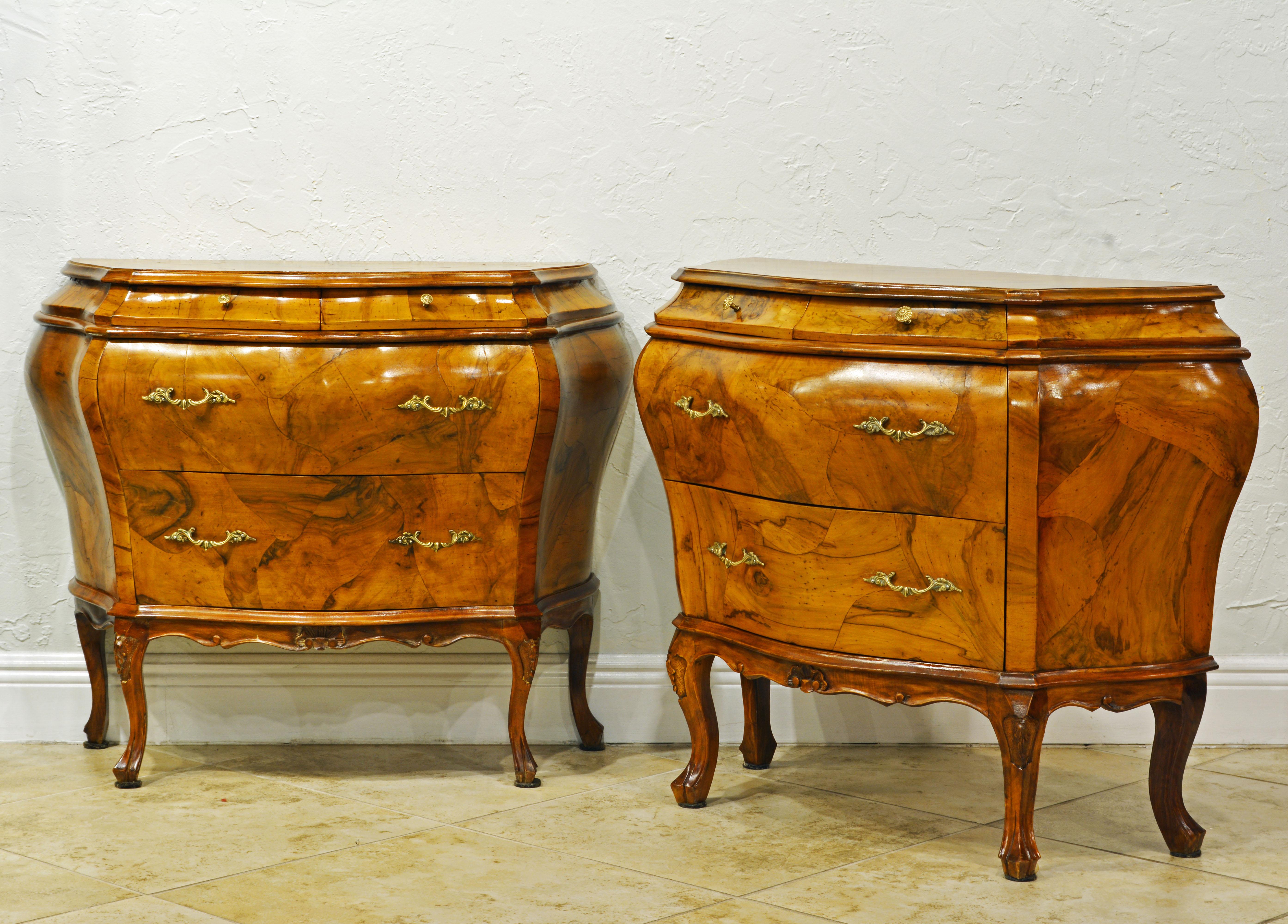 This attractive pair of mid-20th century Italian commodes feature well proportioned bombe forms with two short frieze drawers above the two long drawers and a scalloped carved apron resting on carved cabriole legs and mounted with Rococo style