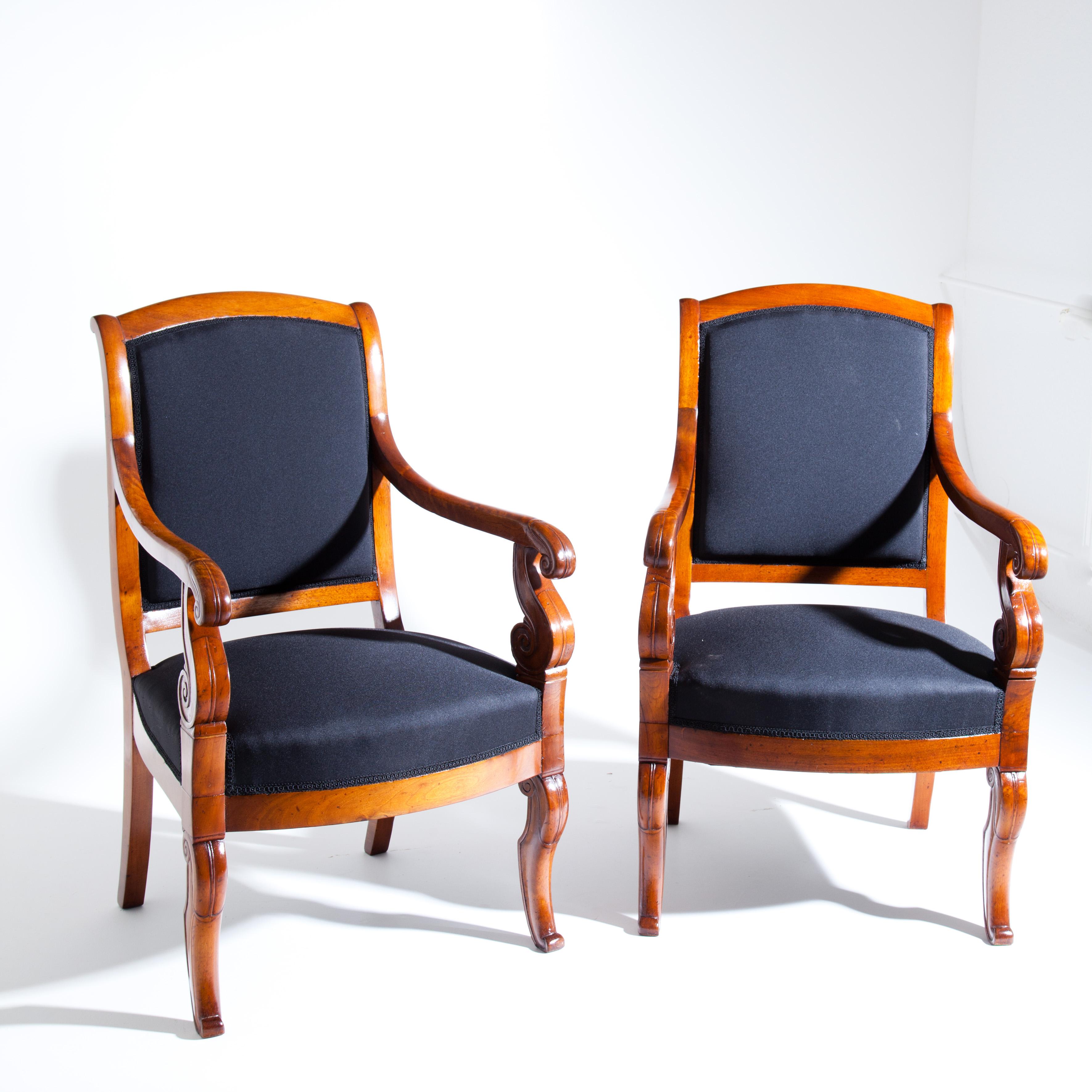 Pair of French armchairs on curved legs at the front and slightly flared rear legs. The armrests bend in a slight curve and rest on s-shaped carved supports. The seats and backrests have been newly covered with a black fabric.
  