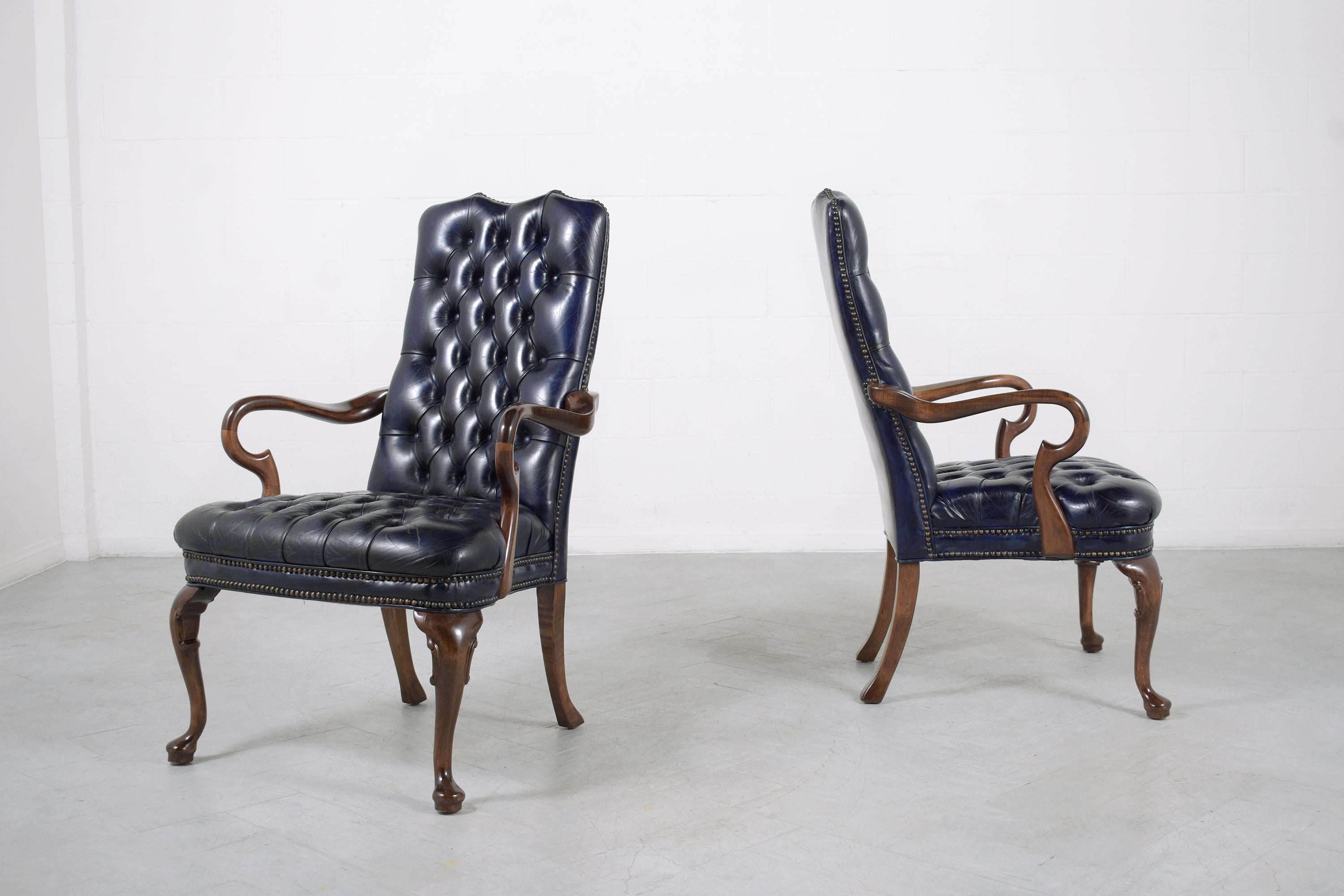 An extraordinary pair of chesterfield executive armchairs handcrafted out of mahogany wood in great condition and are newly restored and refinished by our professional craftsmen team. This elegant pair is eye-catching and features a carved scroll