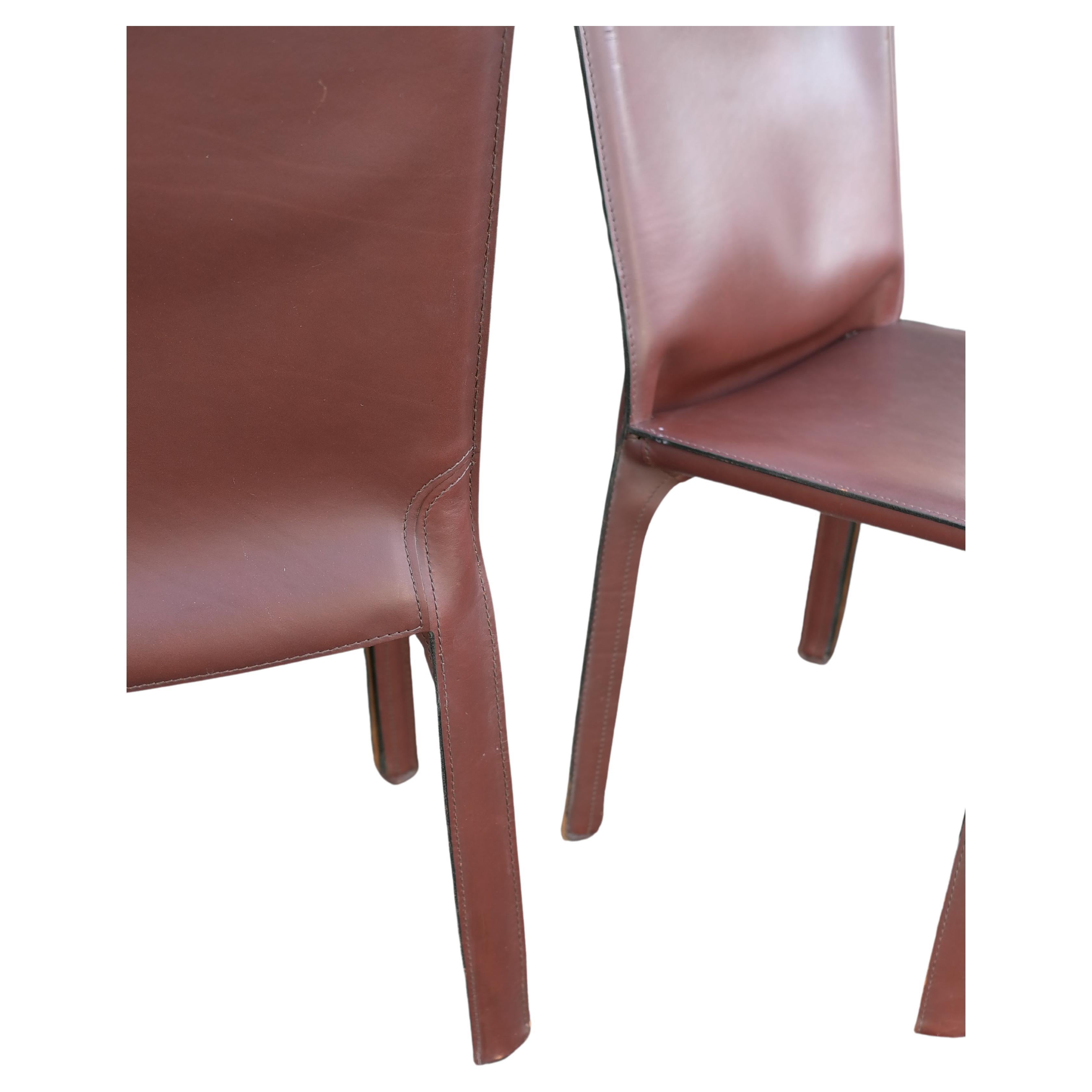 Pair of cab chairs by Mario Bellini for Cassina in chestnut color, Italy, circa 1970s. Wonderful original patina and wear. Broken in like your favorite baseball glove. Signed underneath with Cassina impressed mark on the leather and again on the