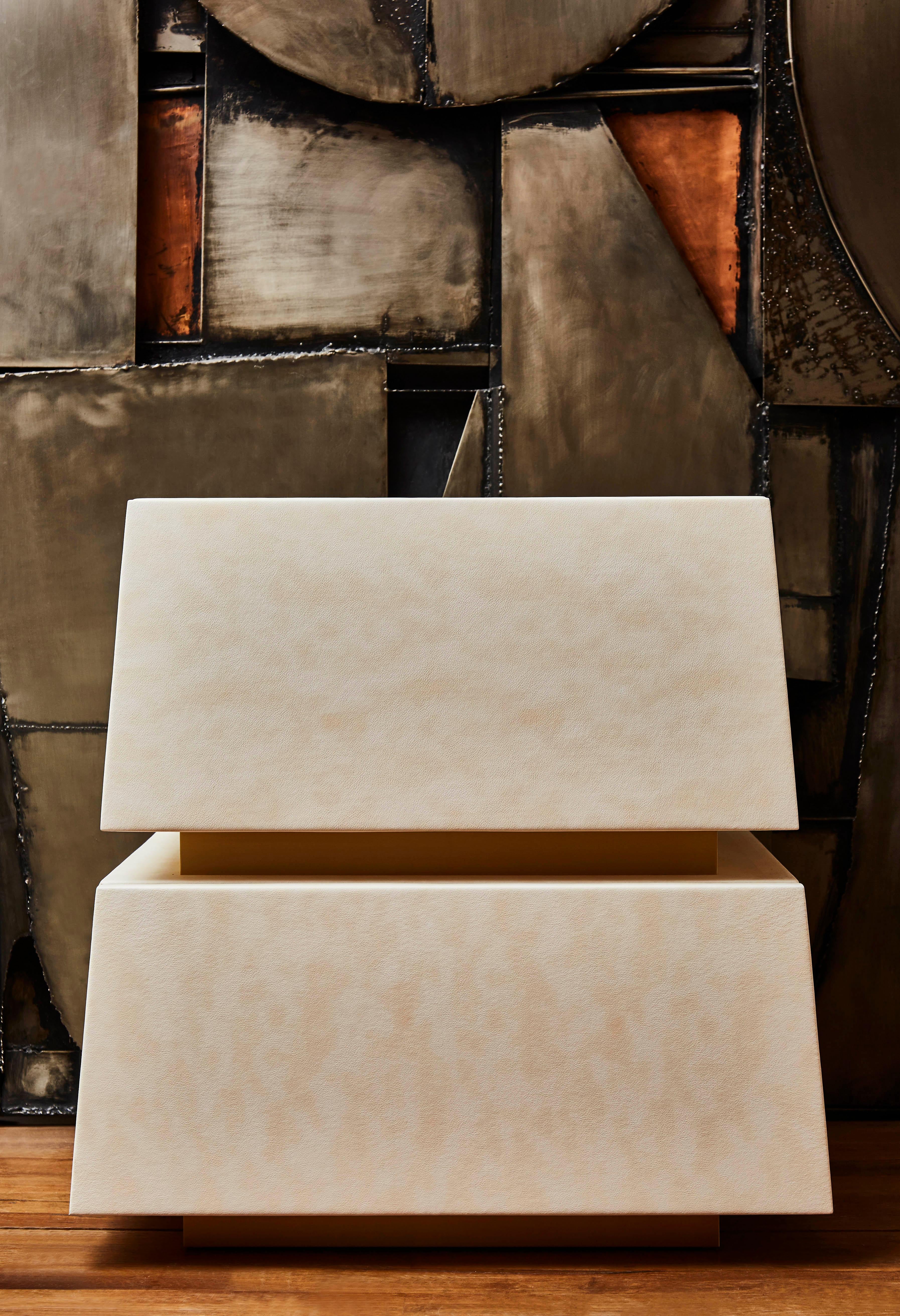 Ein Paar Kommoden aus Holz, gepolstert mit einem cremefarbenen Leder, das wie Pergament gearbeitet ist, um so dünn wie möglich zu sein. Messingring zwischen den 2 Schubladen. Gestaltung durch das Studio Glustin.