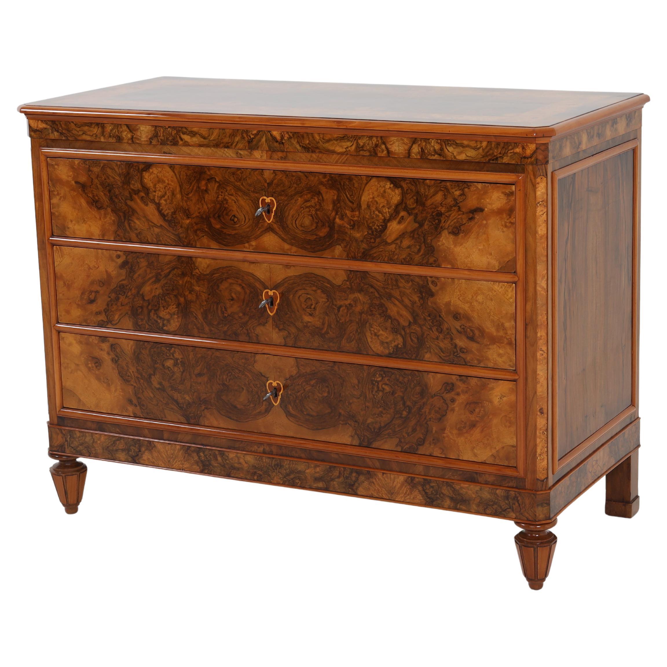 Pair of Italian chests of drawers in walnut and burl veneer with profiled crossbars. The commodes are in a restored and hand polished condition.