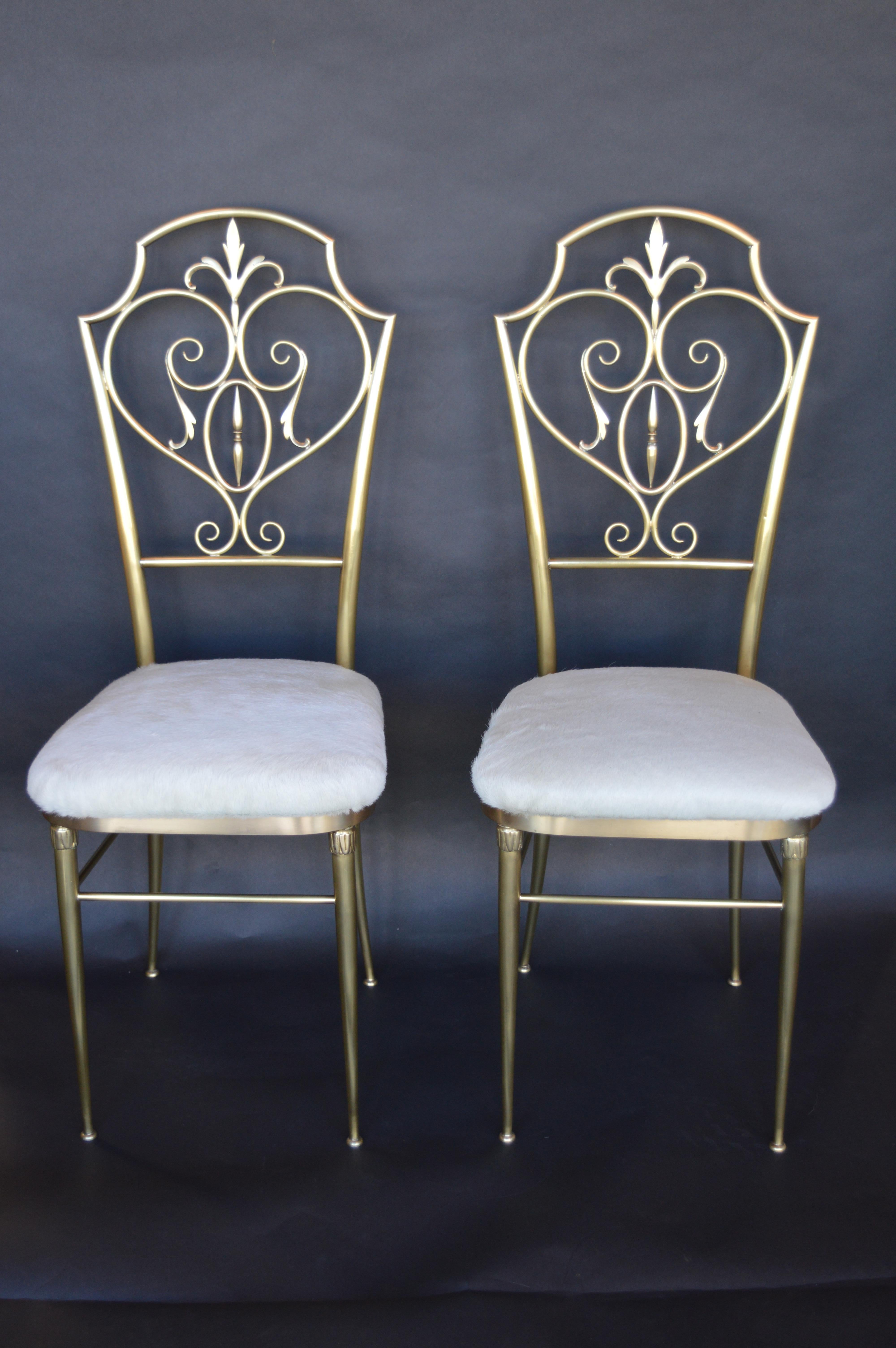 Pair of Chiavari brass chairs with white cow hide seats.