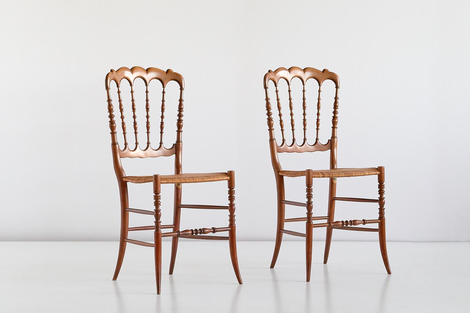 This elegant pair of Chiavari or Chiavarina chairs was designed by Giuseppe Gaetano Descalzi in 1807. The chairs were handmade by Fratelli Zunino and Rivarola in Chiavari in the early 1950s. The natural lacquered frames made of solid beech feature