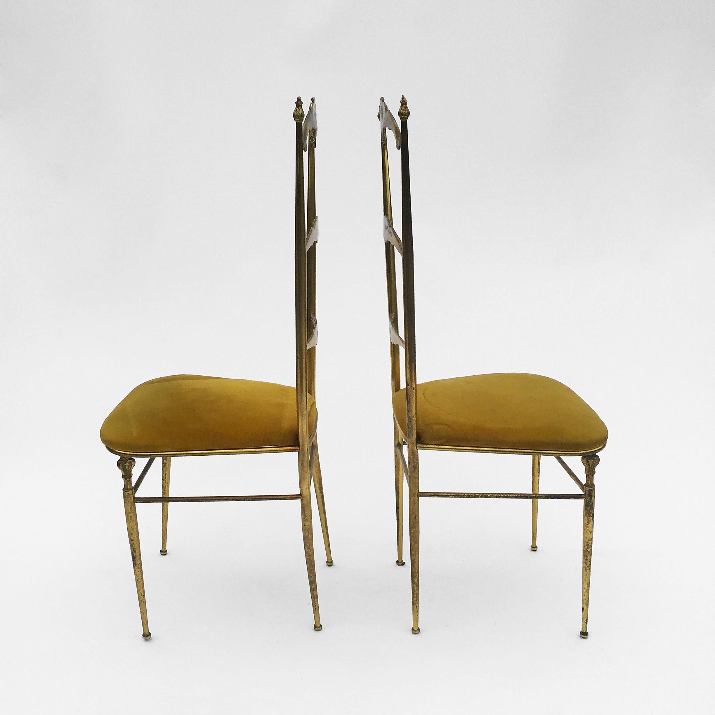 An elegant pair of brass chairs in the style Chiavari a combination of neoclassical and midcentury design with the original upholstery. Wear consistent with age and use. Brass surface has an aged patina, the brass frame is hallow therefore not